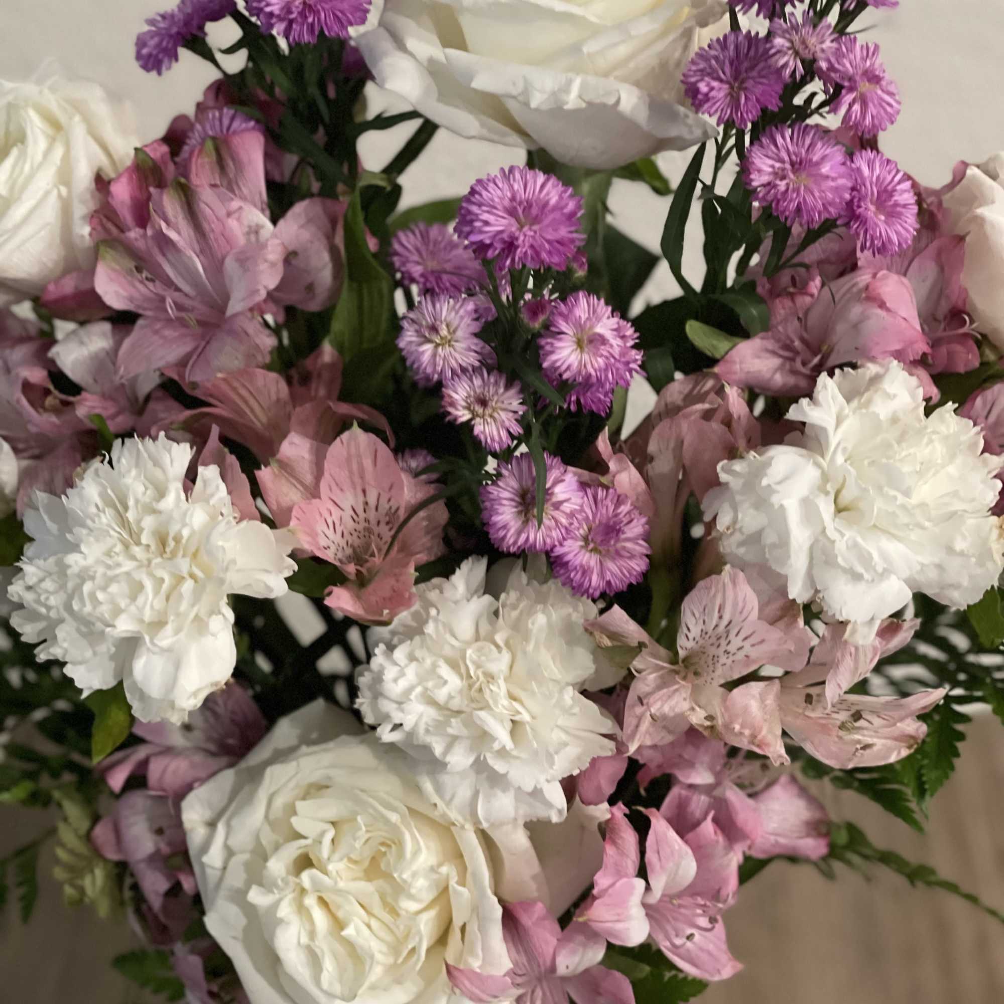 Bouquet of white roses, pink alstroemeria, and purple pom flowers