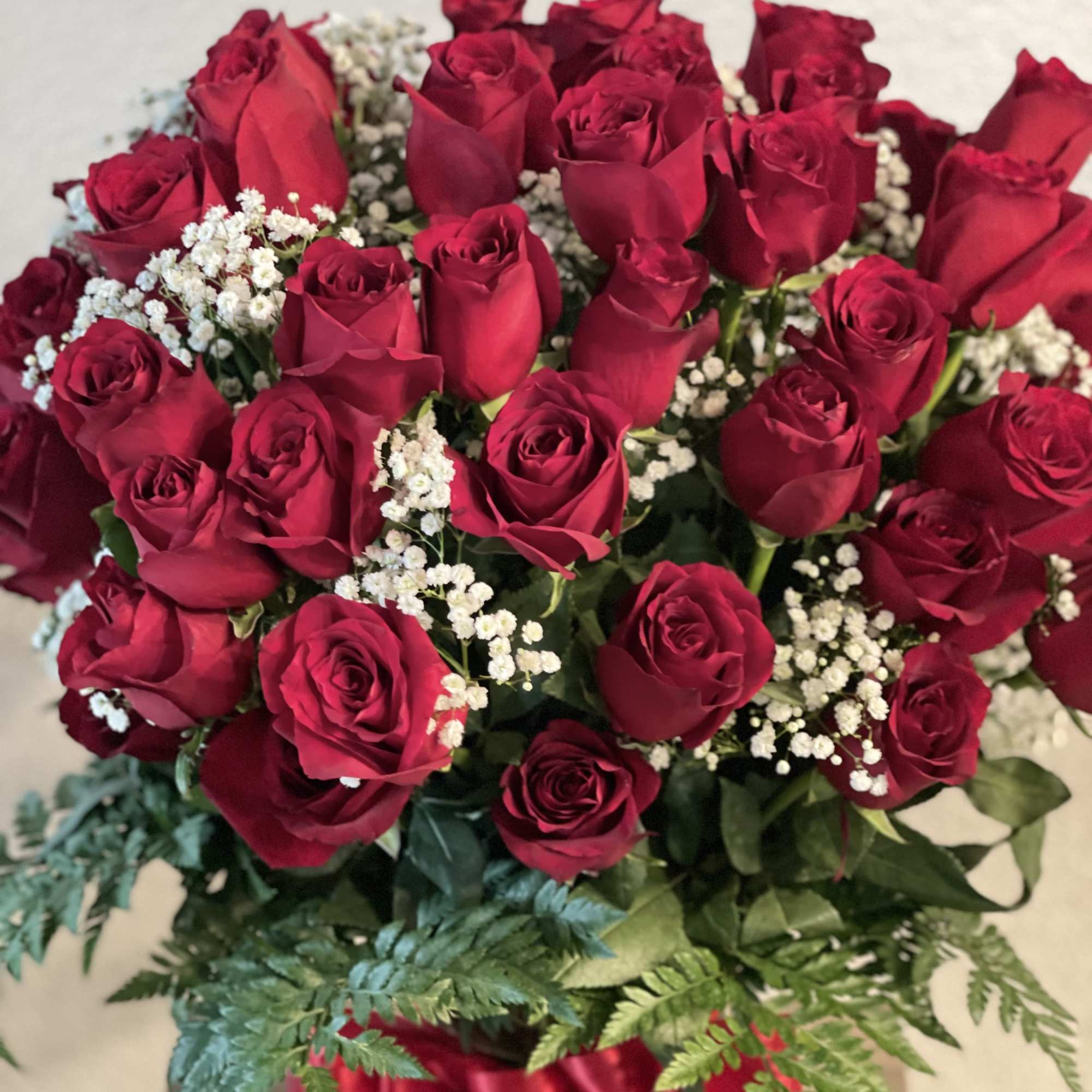 Bouquet of red roses with white baby's breath and a red ribbon