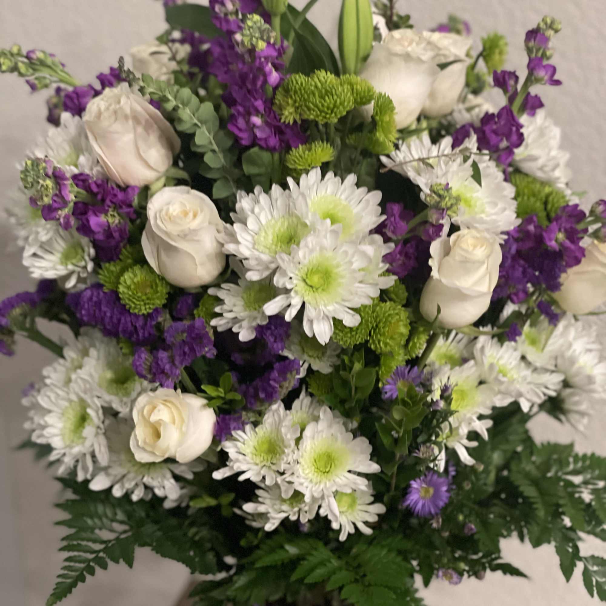 Bouquet of white roses, white daisies, and purple flowers