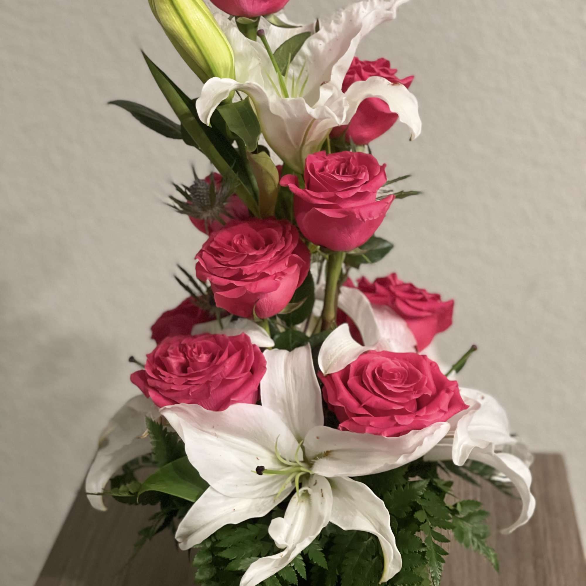 Pink roses and white lilies arranged in a black vase