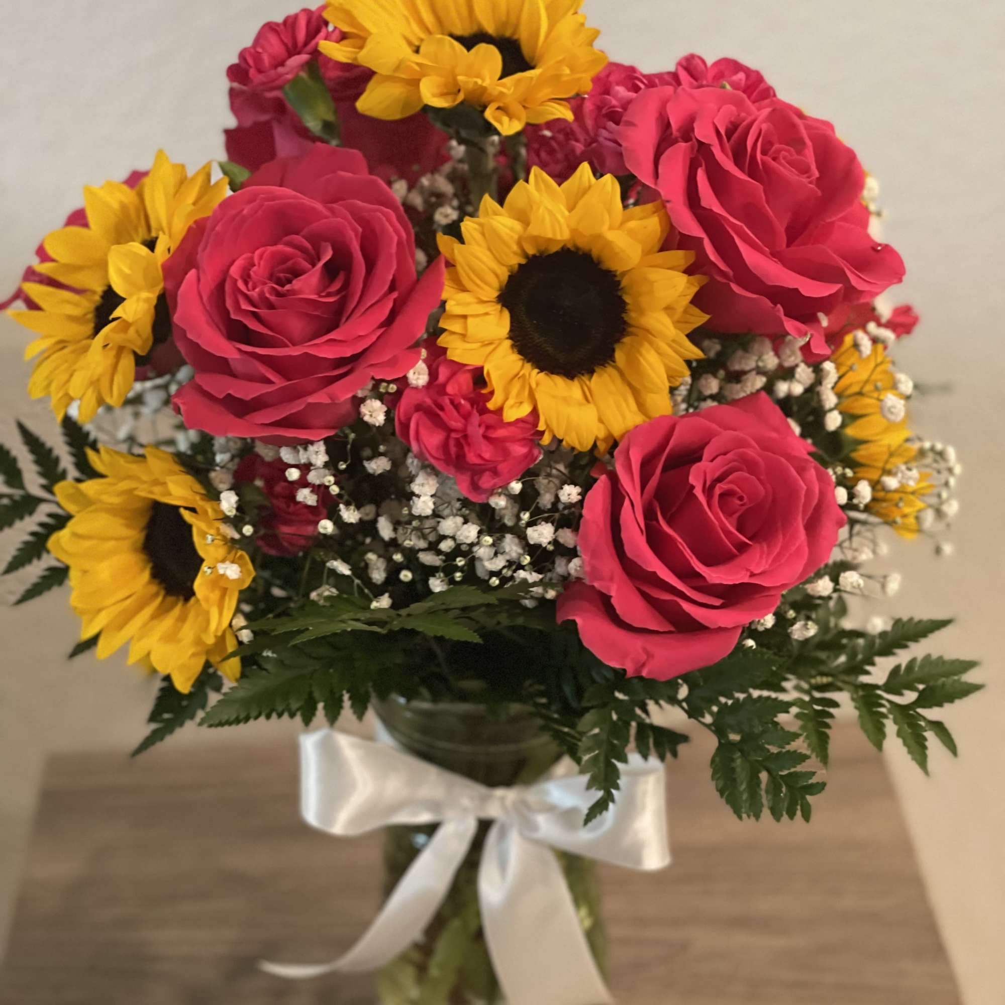 Bouquet of pink roses and yellow sunflowers in a glass vase with a white ribbon, photo 2 of 3