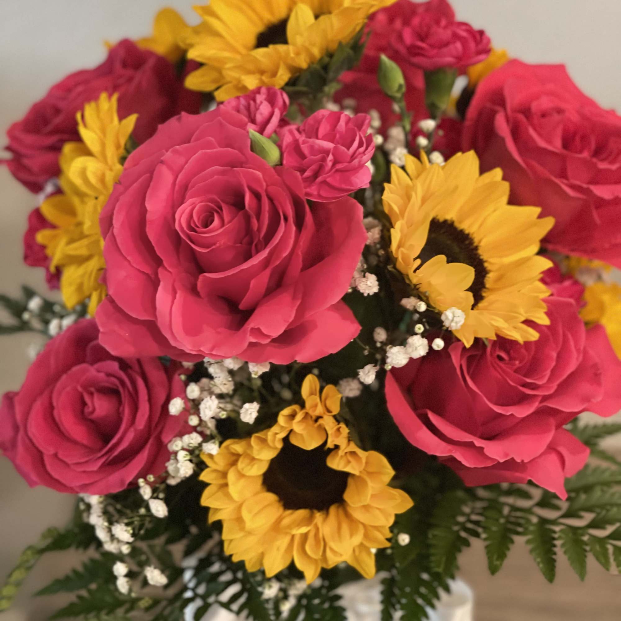 Bouquet of pink roses and yellow sunflowers with baby's breath