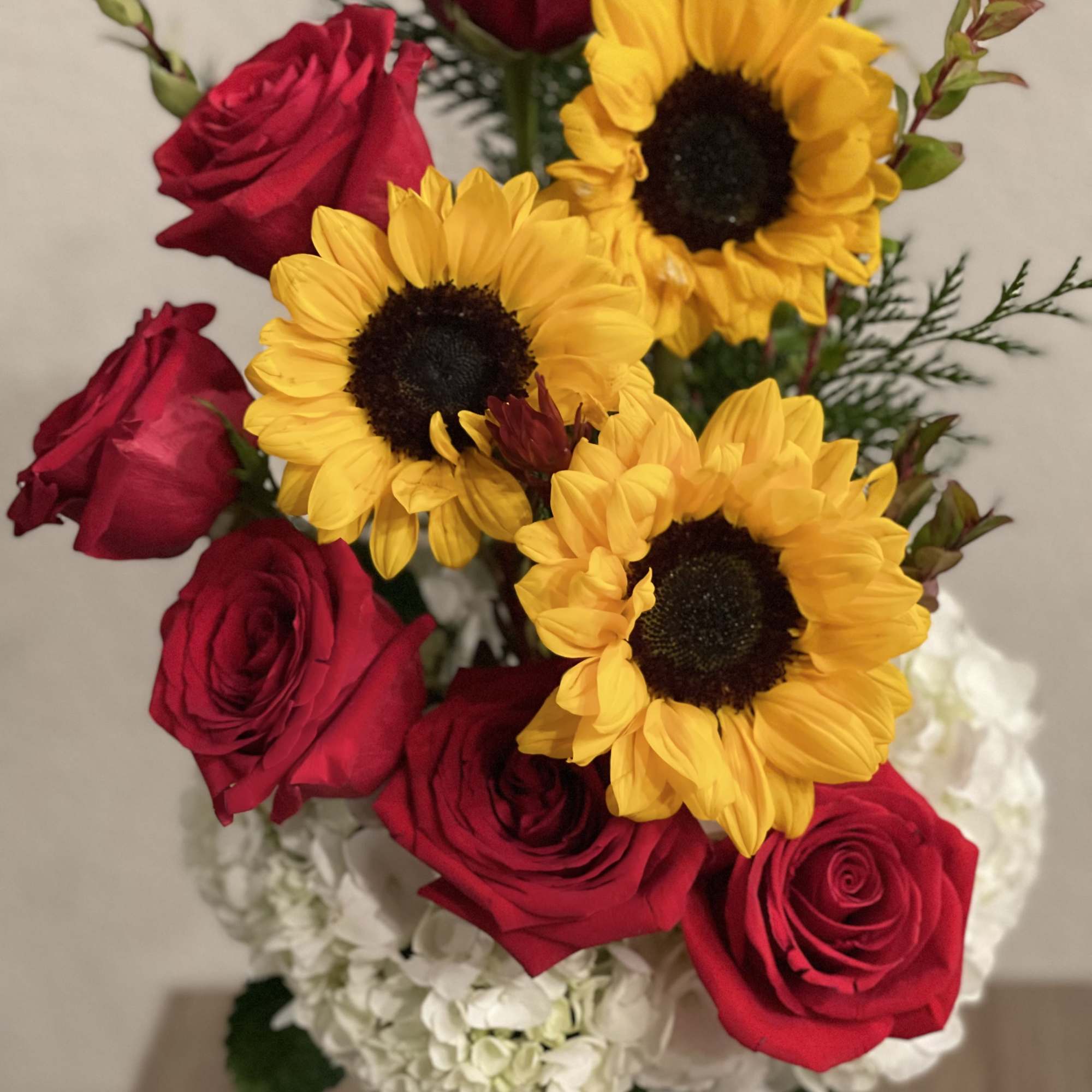 Bouquet of red roses and yellow sunflowers with white hydrangeas