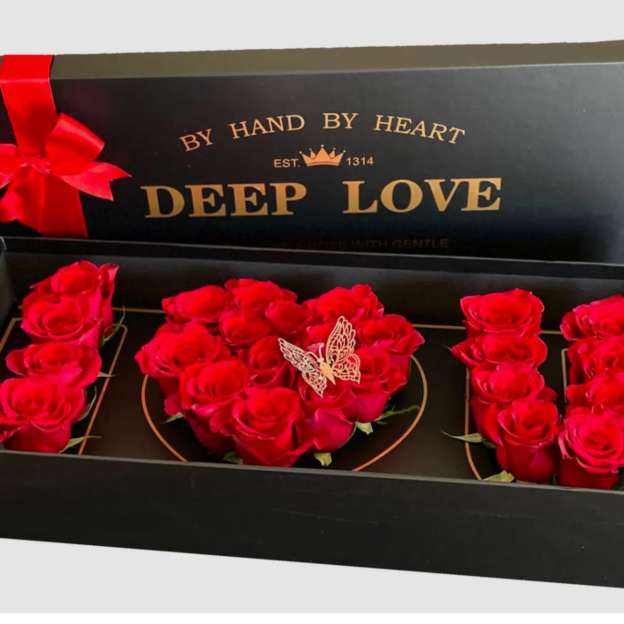 Red roses arranged in a black gift box with a ribbon and butterfly decoration