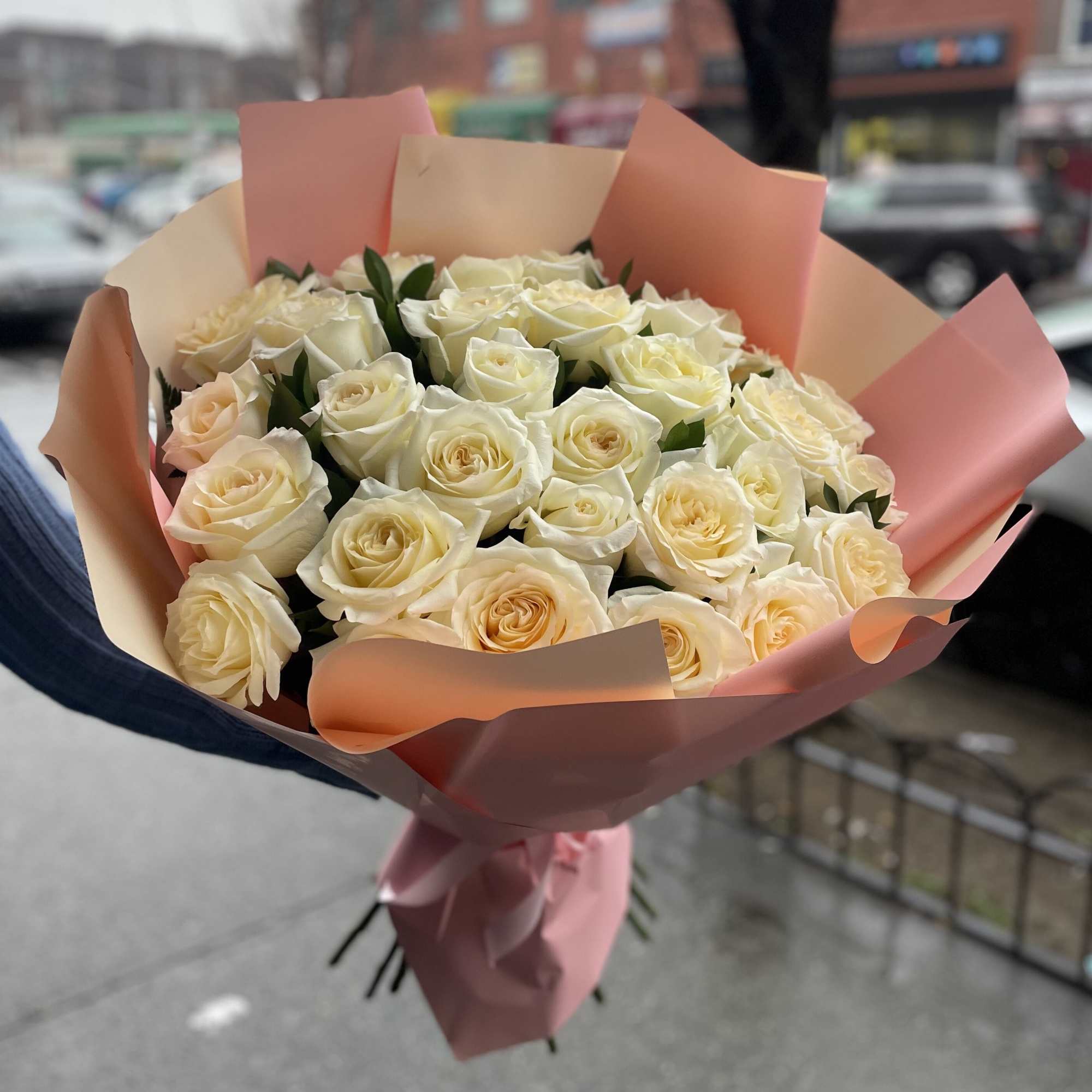 Bouquet of cream roses wrapped in pink paper