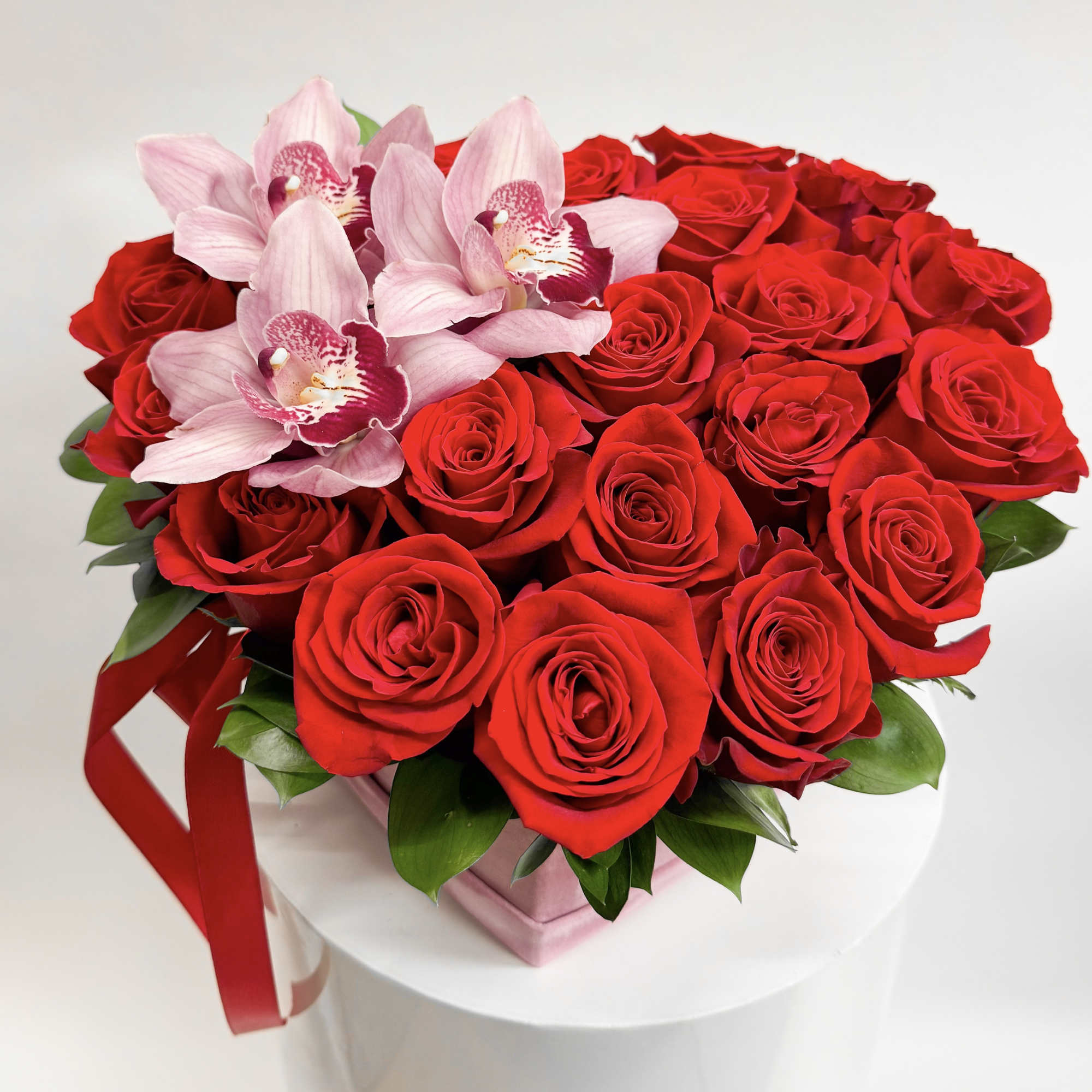 Heart-shaped bouquet of red roses with pink orchids