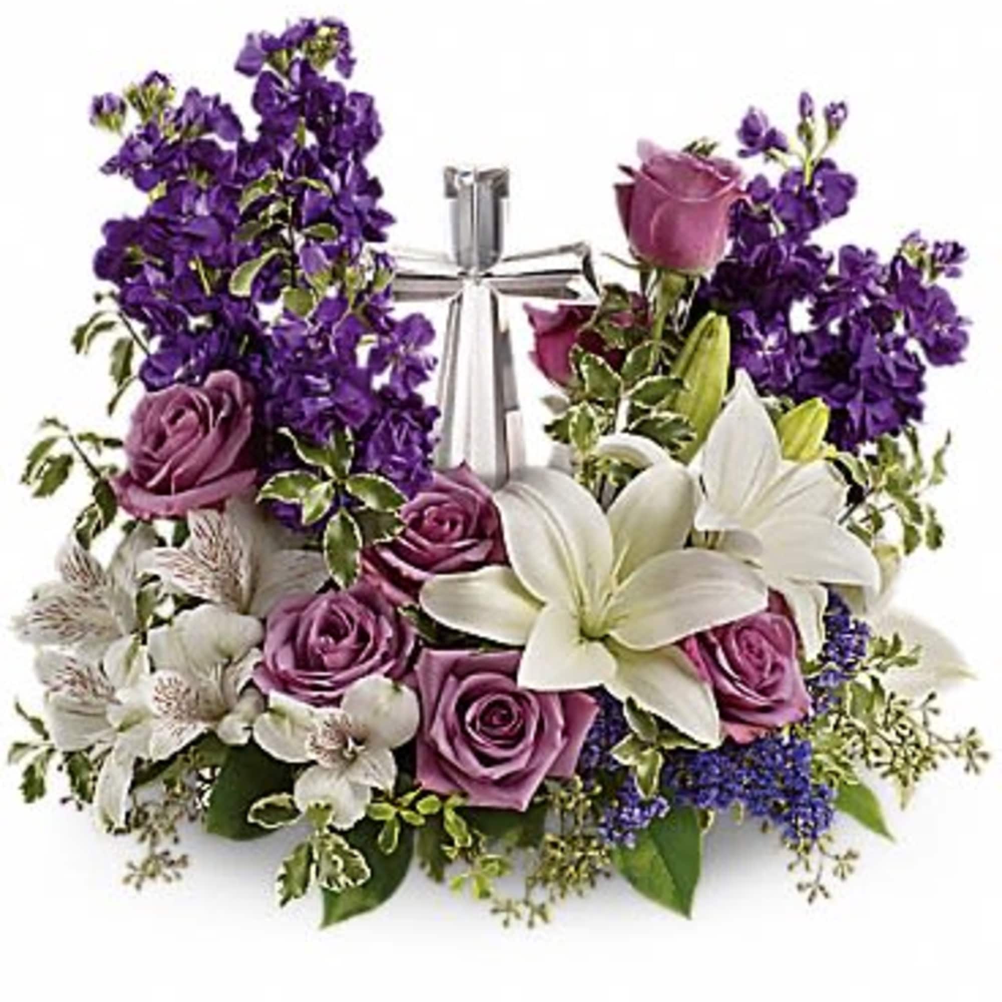 Purple and white floral arrangement with roses and lilies tied with a silver ribbon
