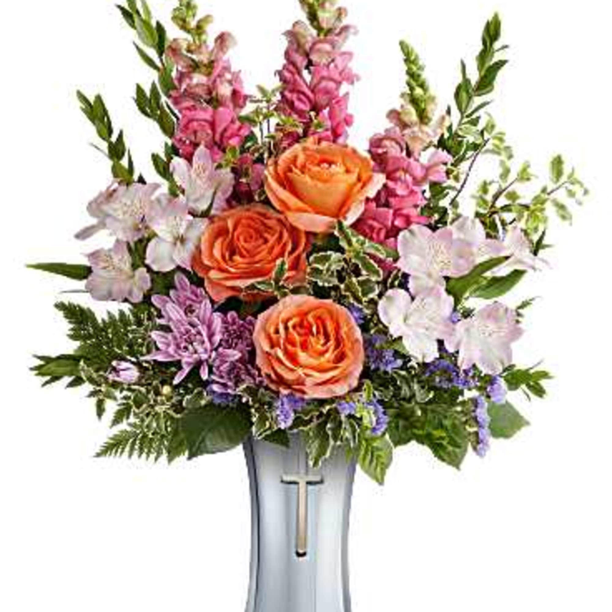 Orange roses and pink snapdragons in a silver vase