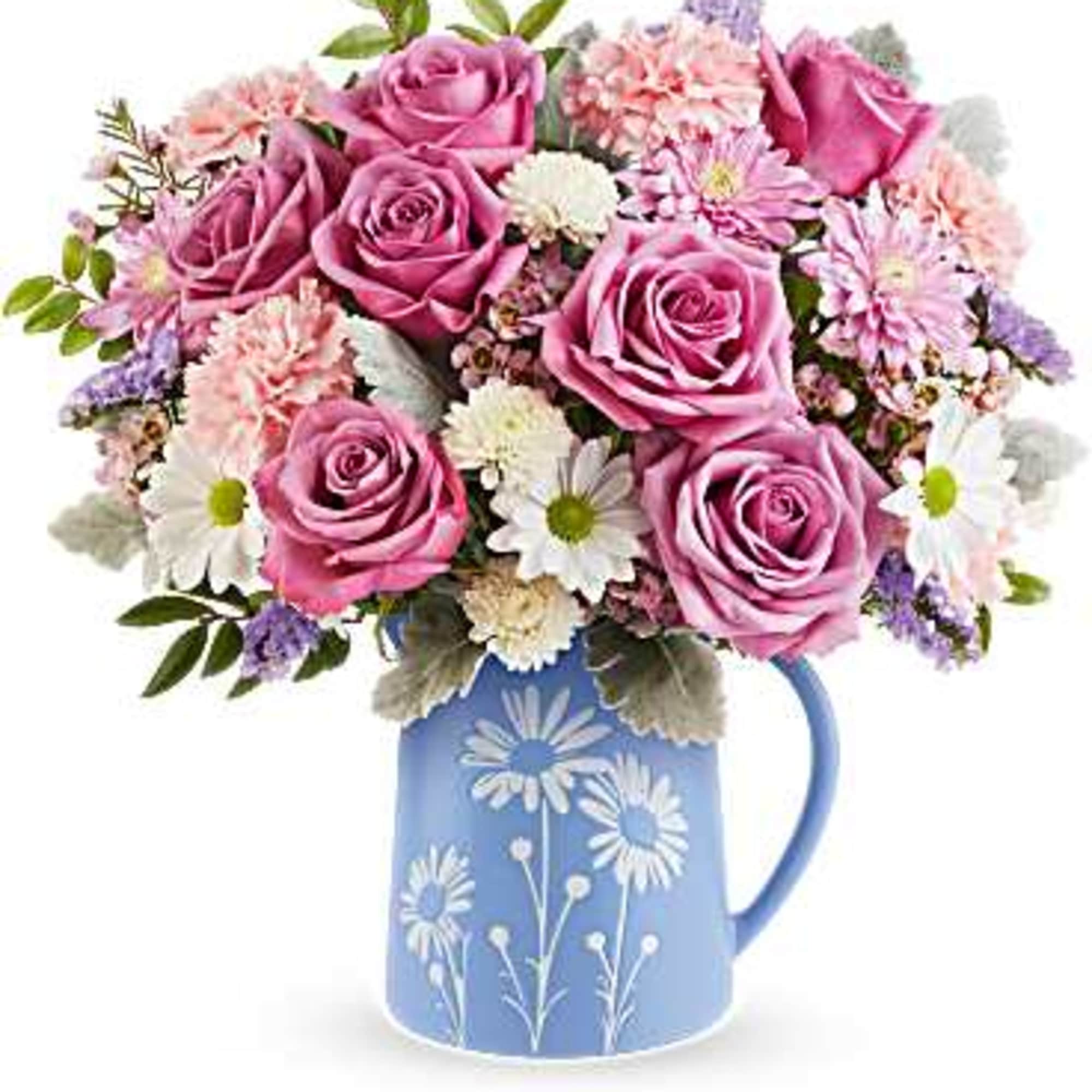 Pink roses and daisies arranged in a blue floral pitcher