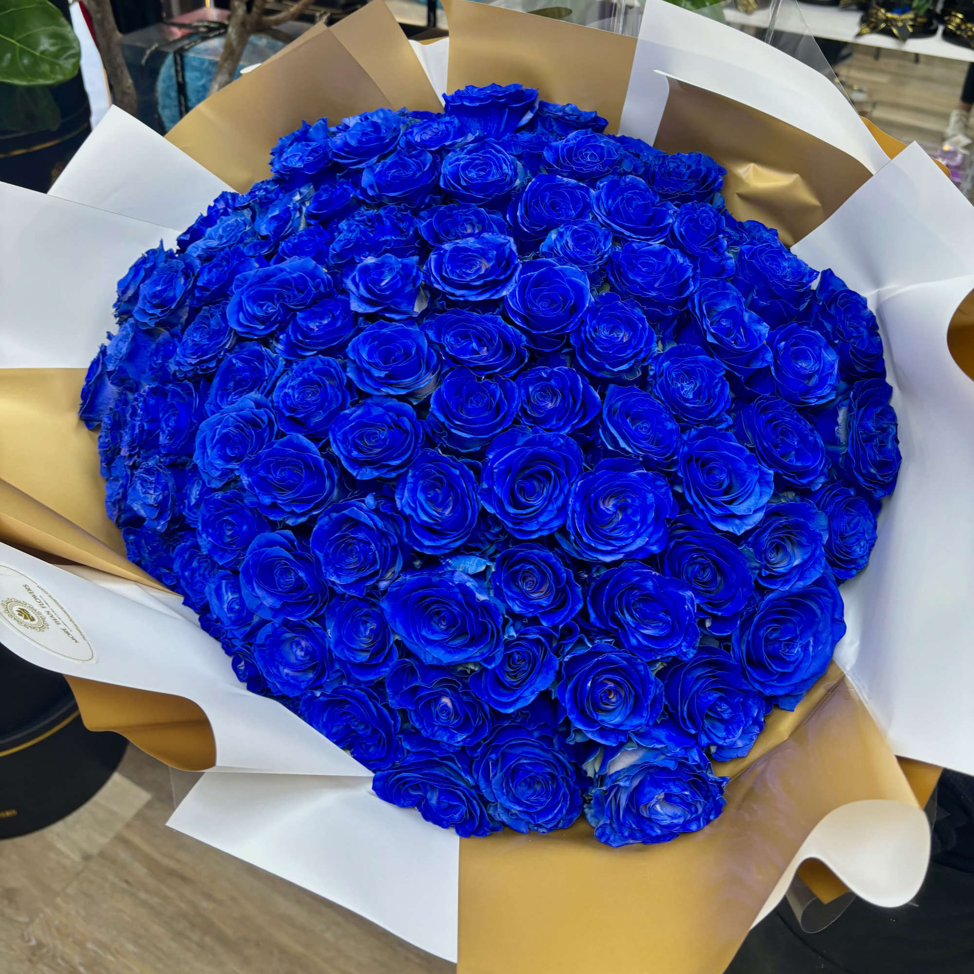 Large bouquet of vivid blue roses wrapped in white and gold paper, photo 3 of 3