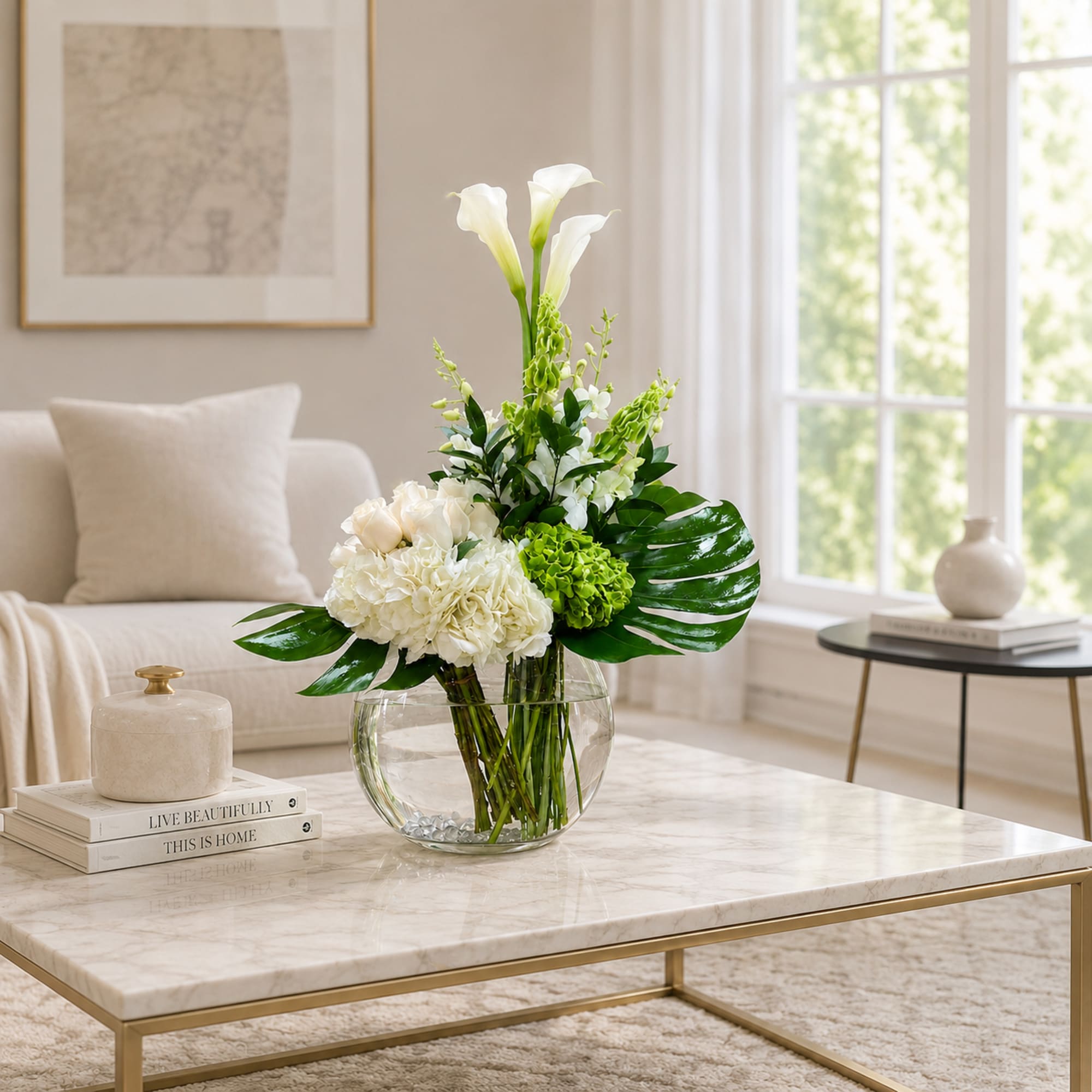White calla lilies and mixed white flowers in a clear glass vase