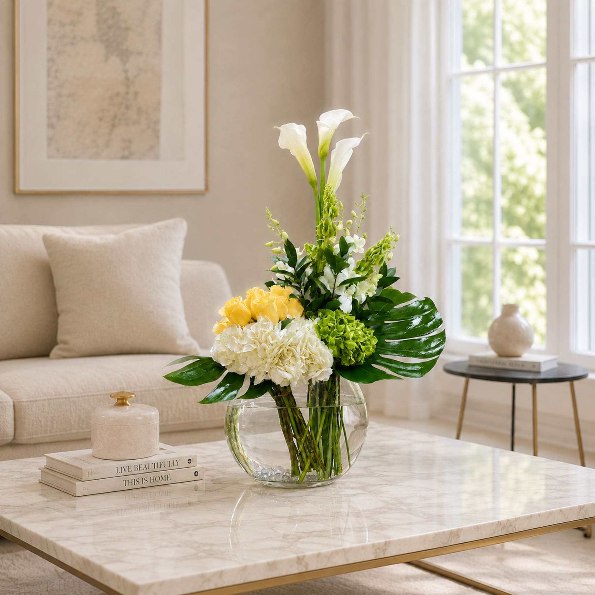 White calla lilies and yellow roses in a clear glass vase