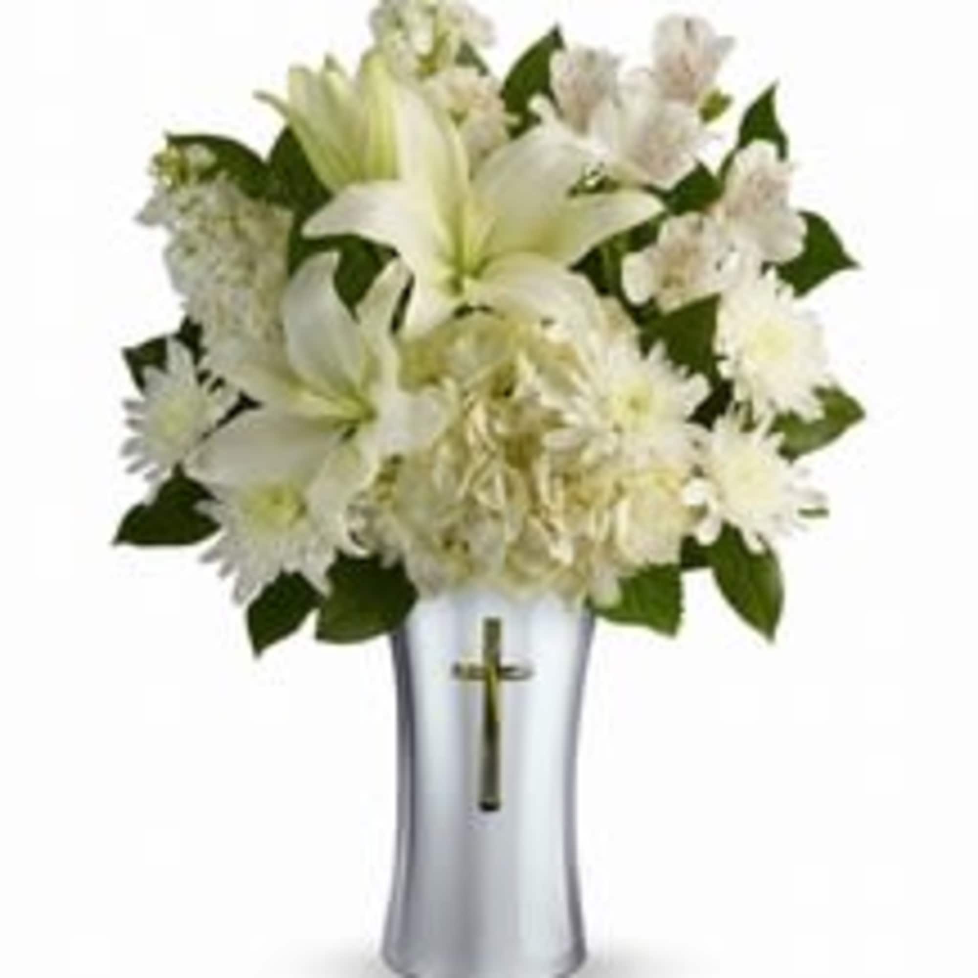 White floral arrangement in a silver vase with a cross emblem