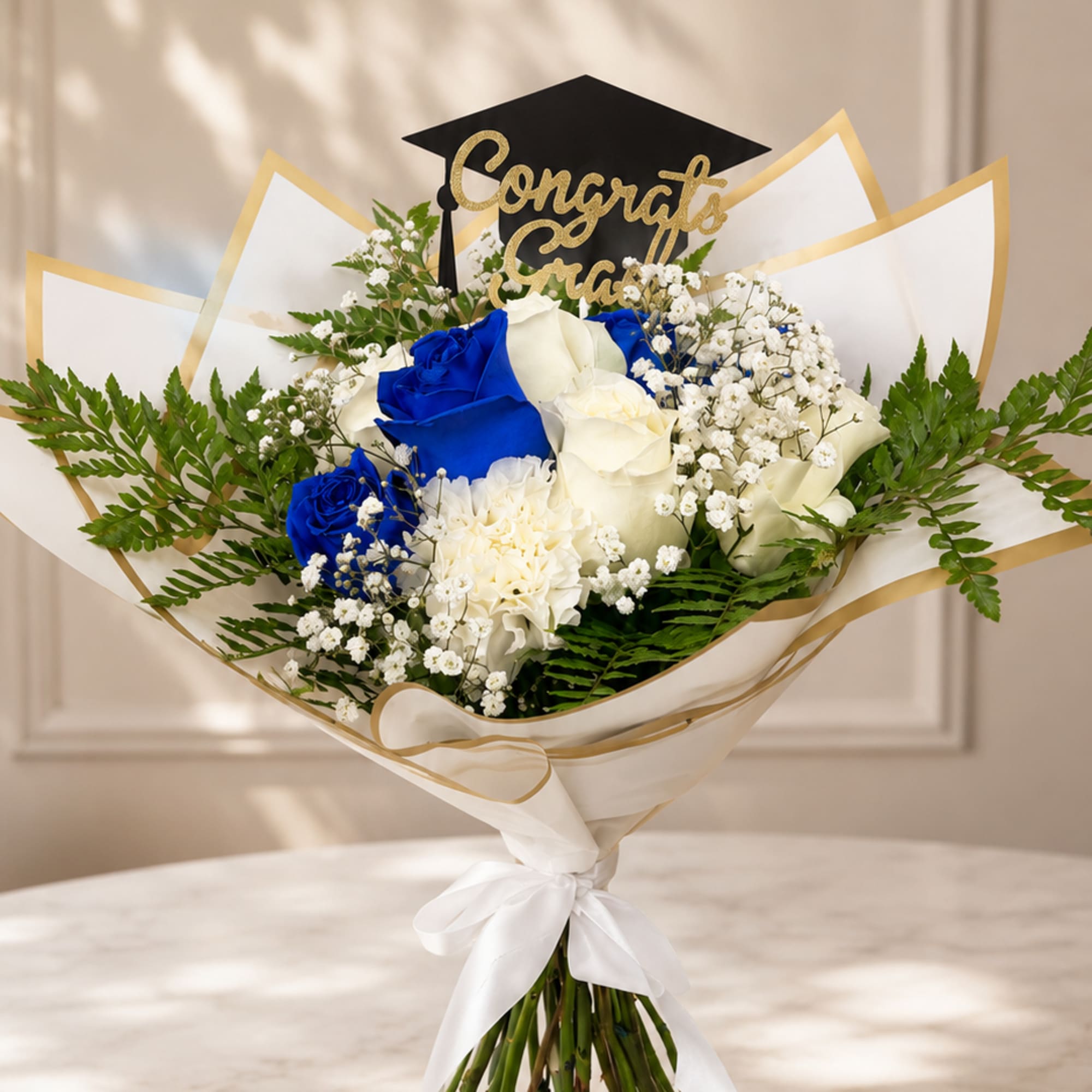 Bouquet of blue and white roses with a graduation topper