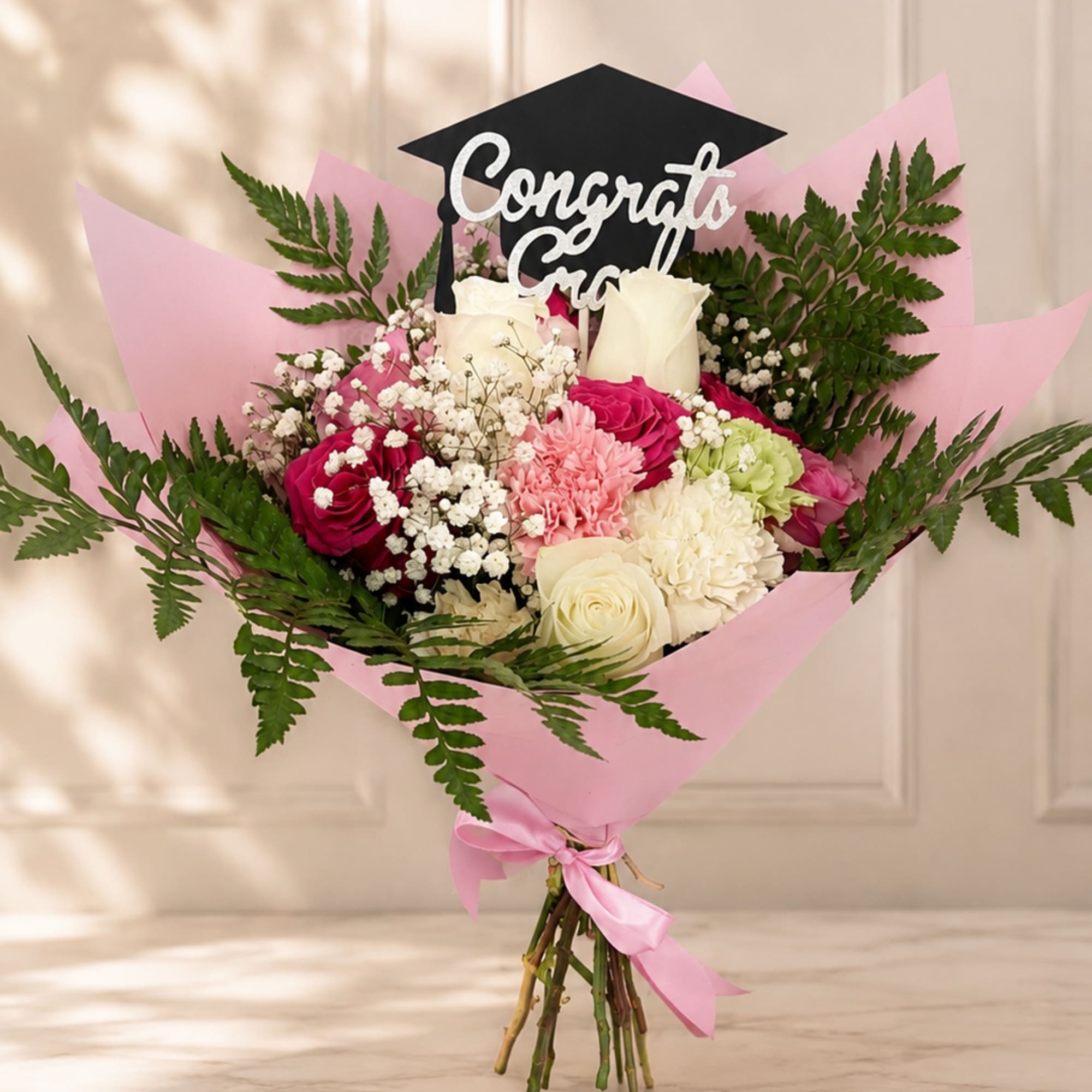 Pink and white bouquet with a graduation topper and ribbon