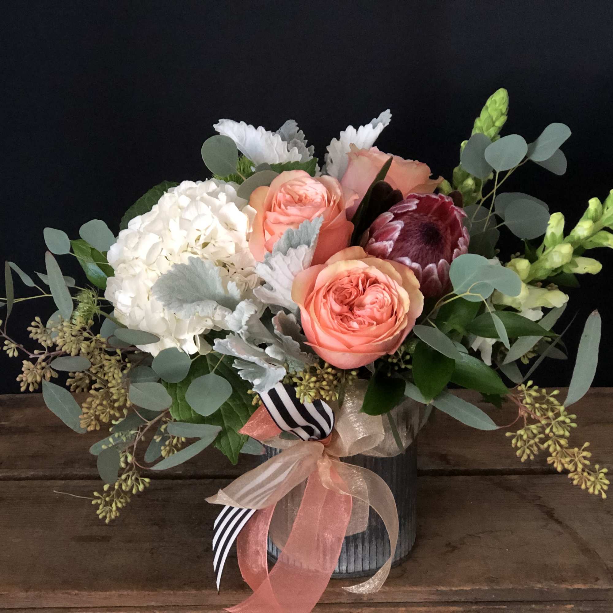 Bouquet of peach roses, white hydrangea, and mixed greenery in a vase, photo 2 of 2