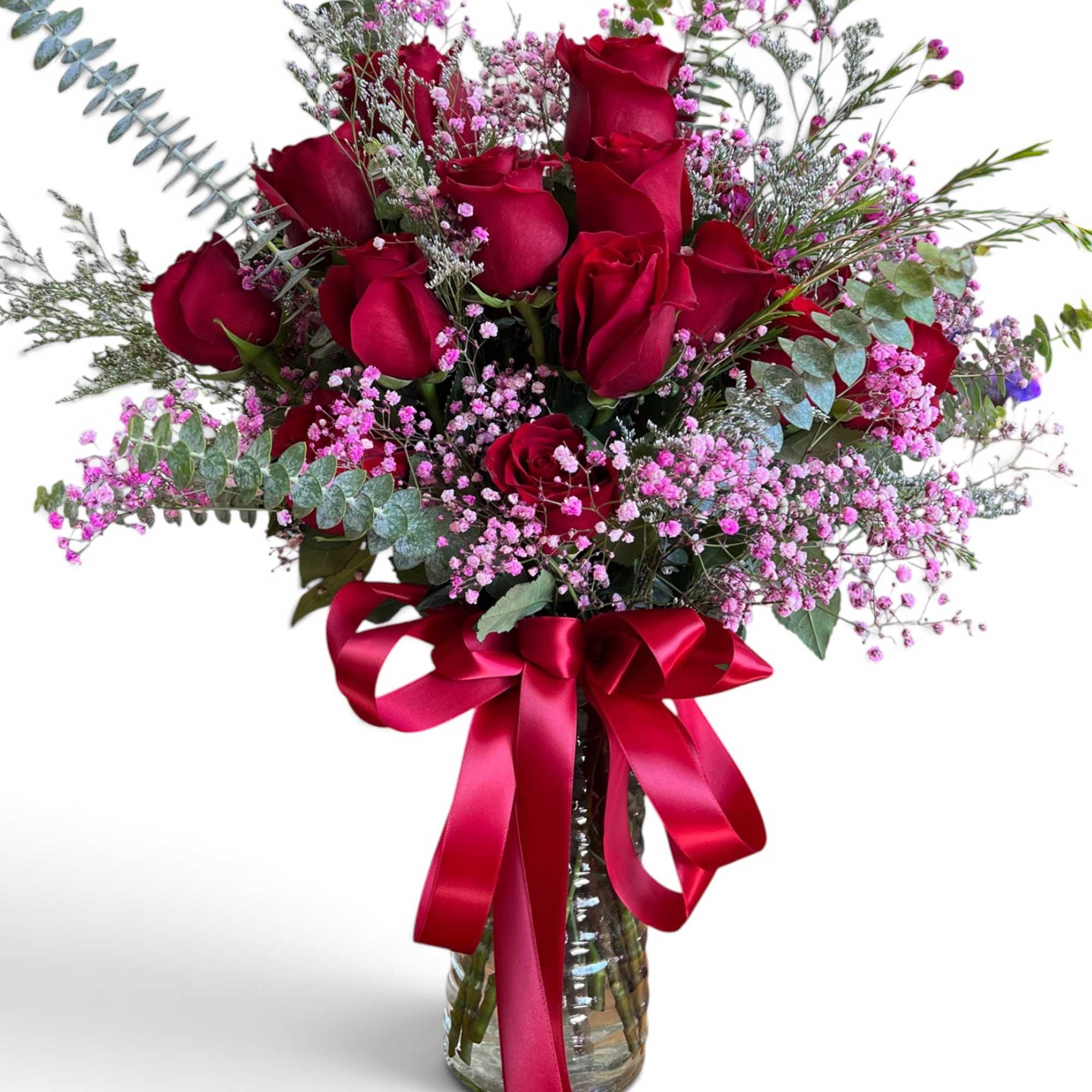 Bouquet of red roses with pink filler flowers in a glass vase