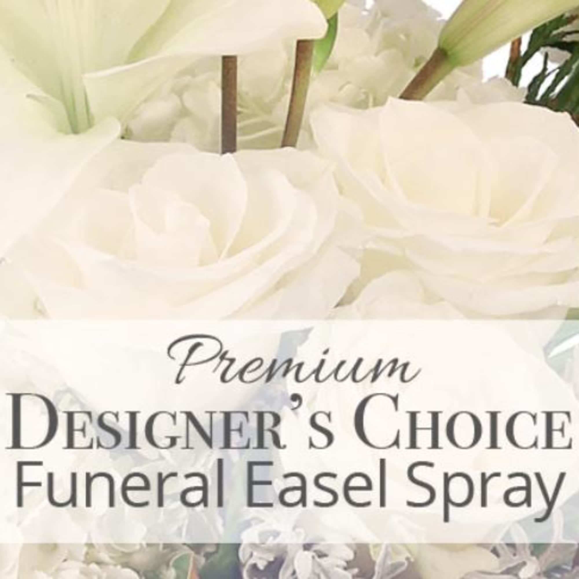 White funeral easel spray with large blooms and a printed label