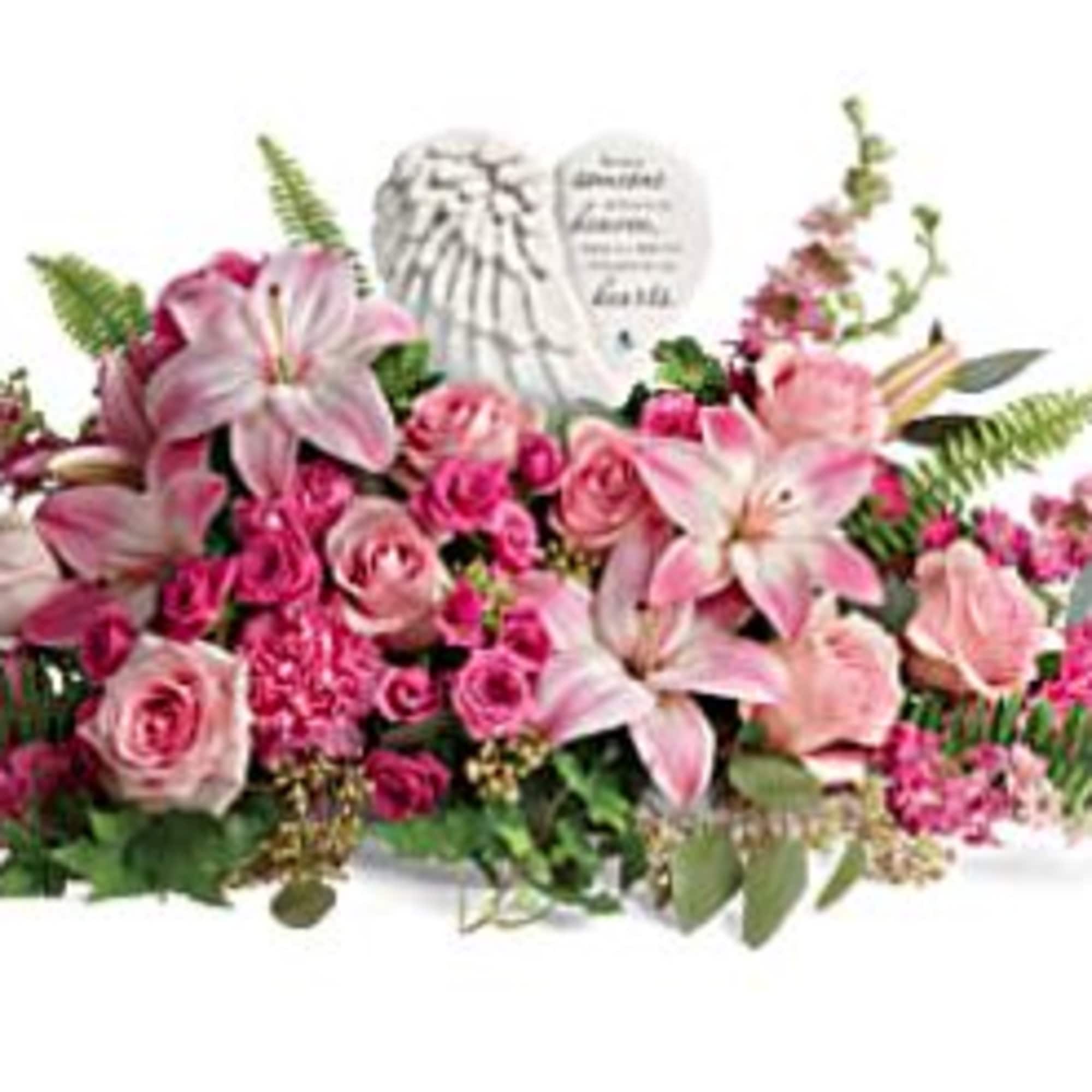 Pink lilies and roses arranged around a memorial plaque