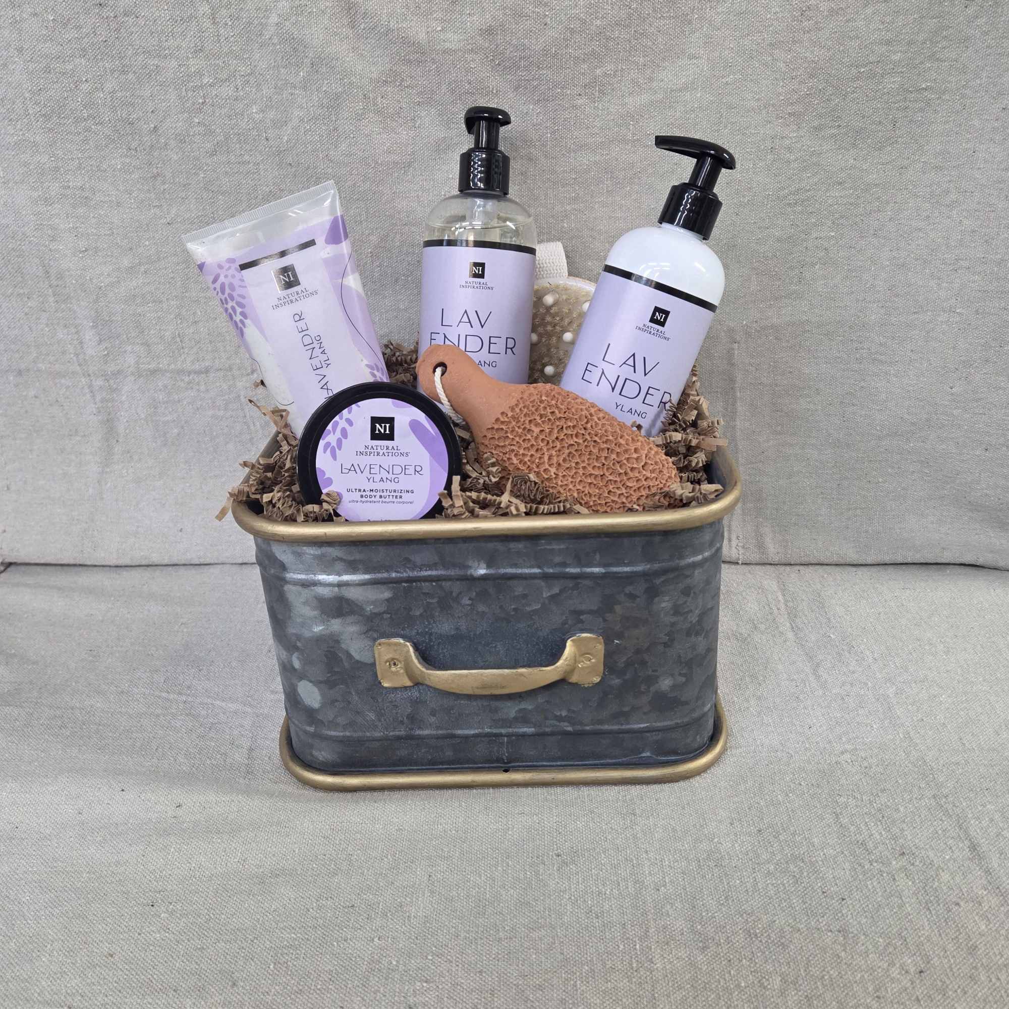 Lavender-scented bath and body gift set in a metal tin with bottles, tube, jar, and sponge