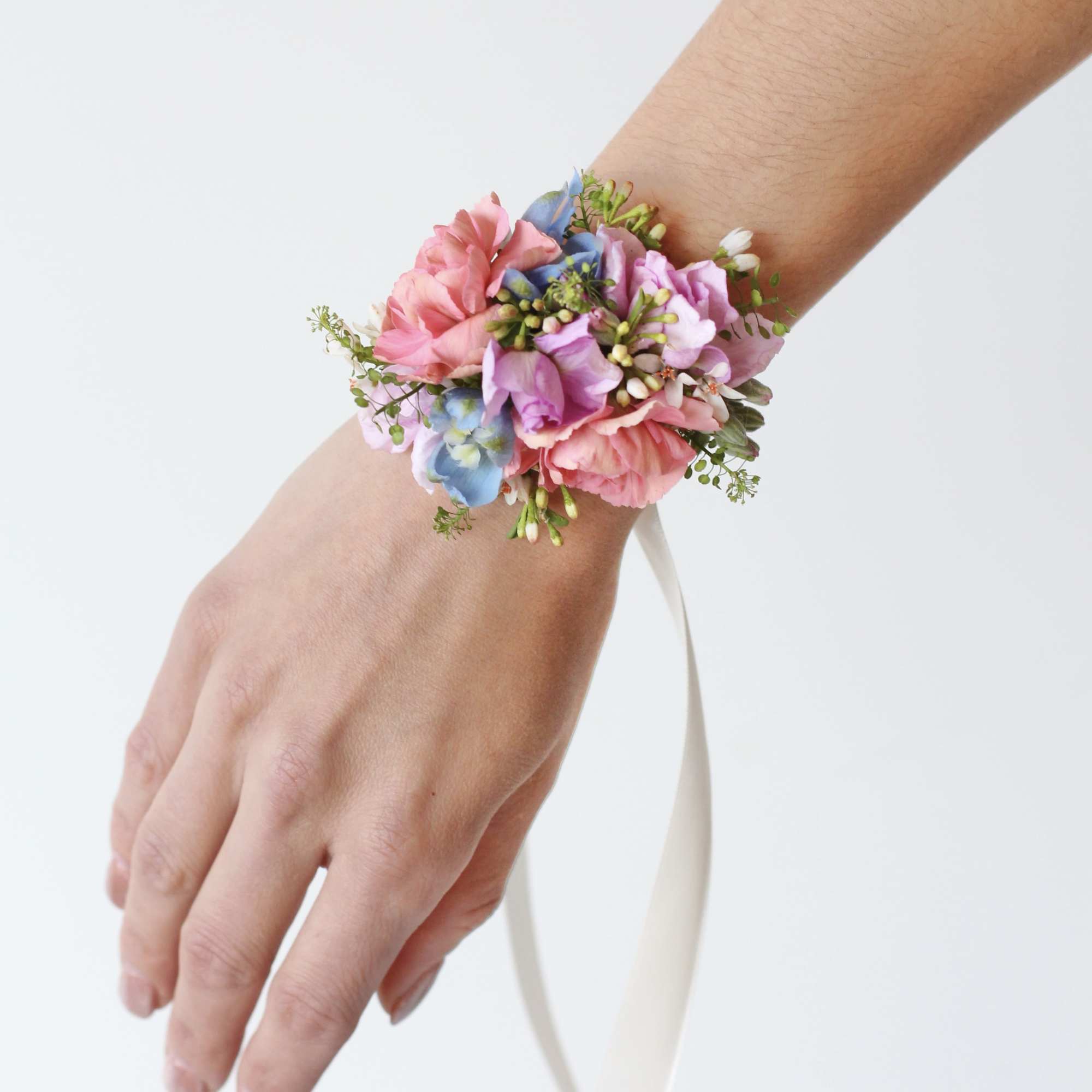 Pastel floral wrist corsage with pink, purple, and blue blooms