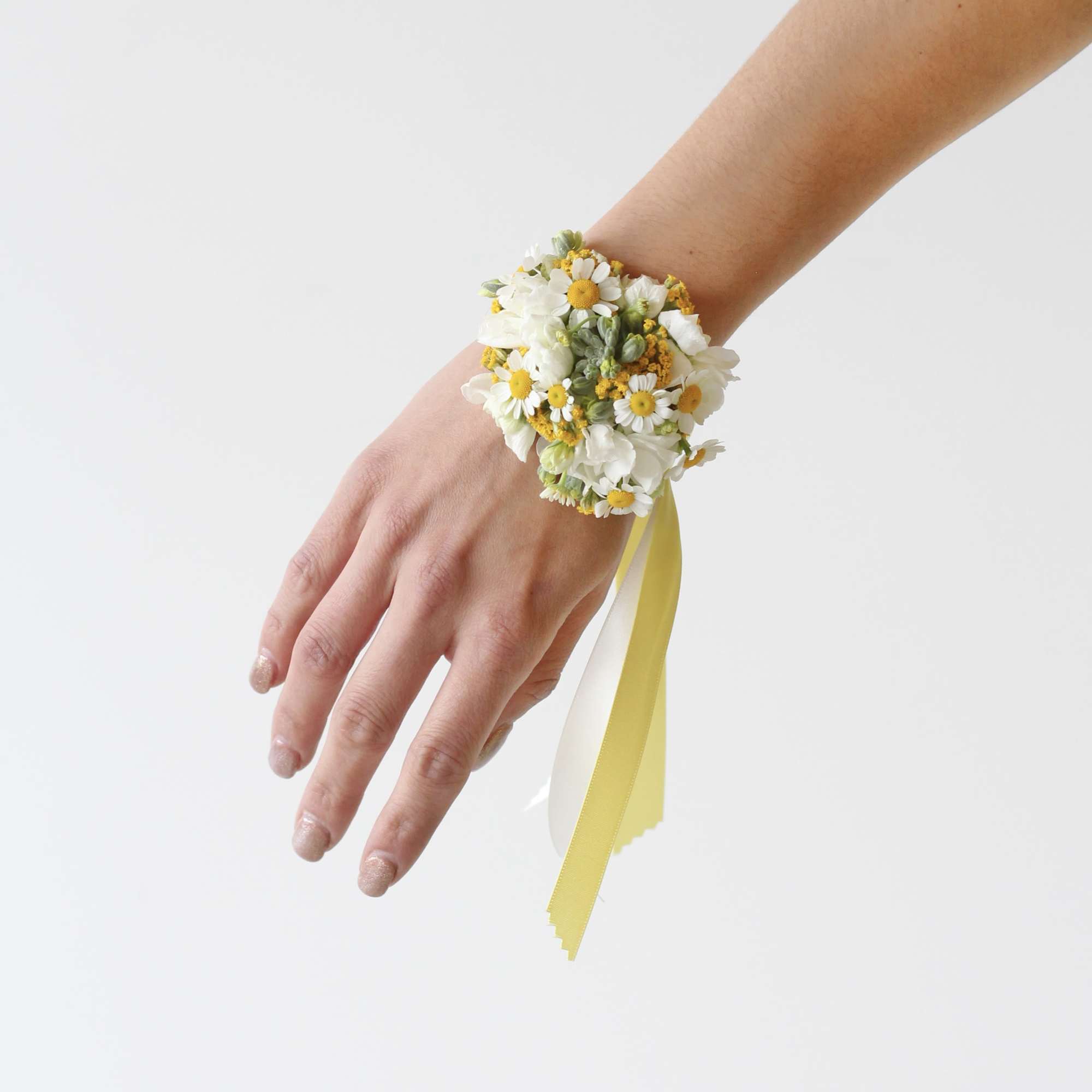 White daisy wrist corsage with yellow ribbon