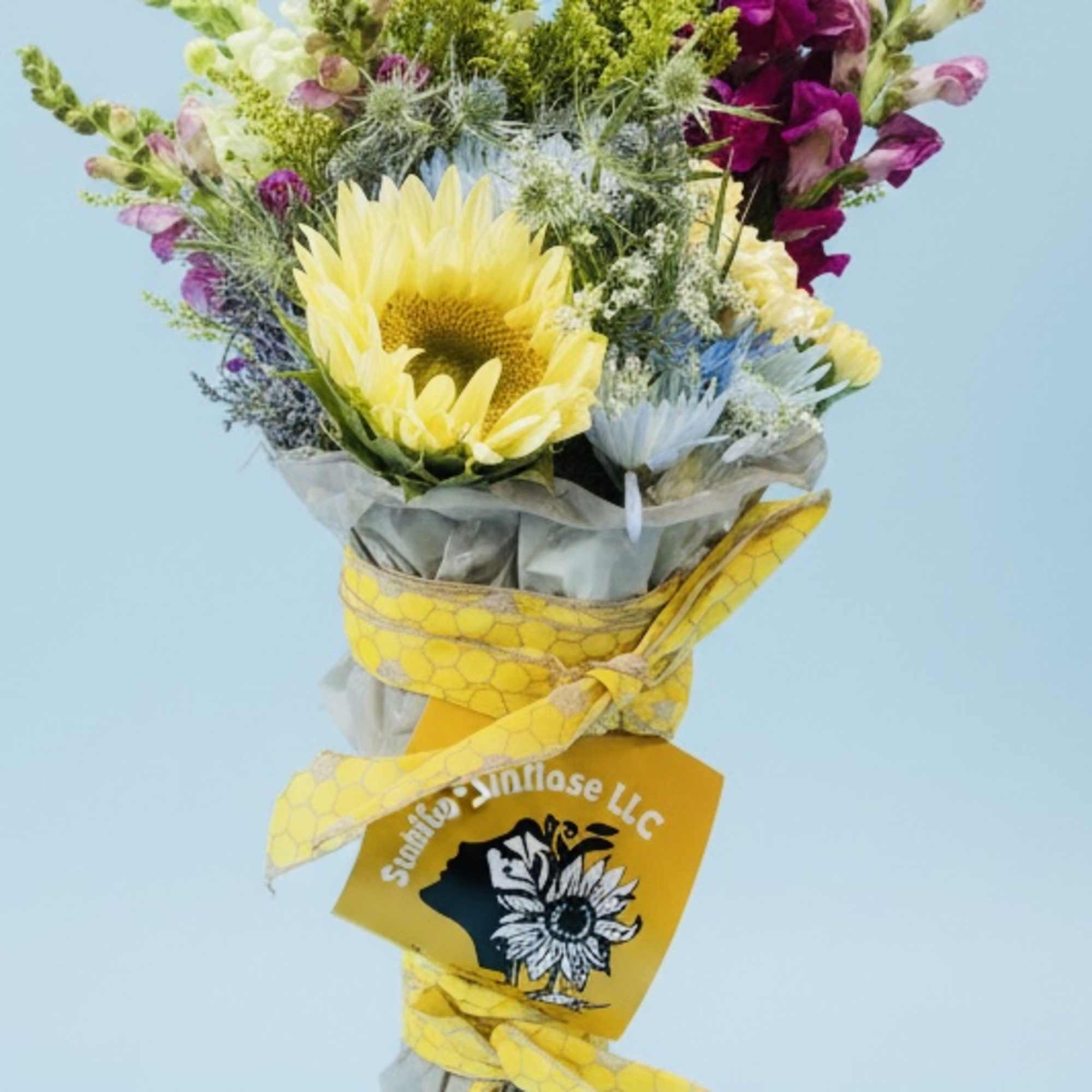 Bouquet with a yellow sunflower and purple snapdragons wrapped in yellow ribbon