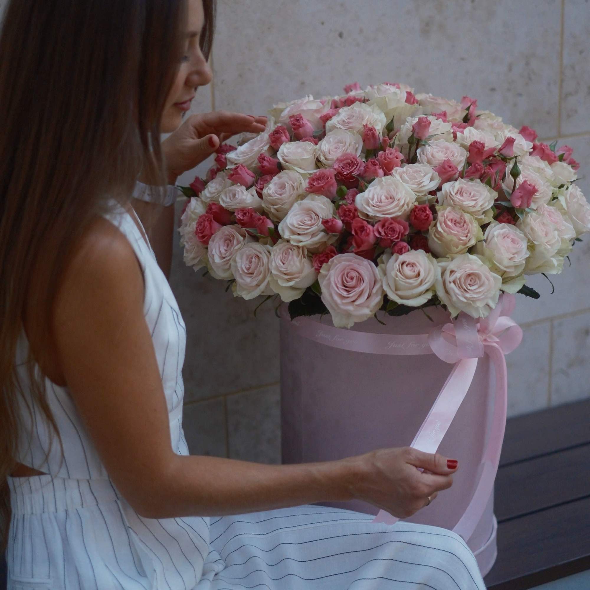 Large pink and white rose arrangement in a round hatbox with ribbon