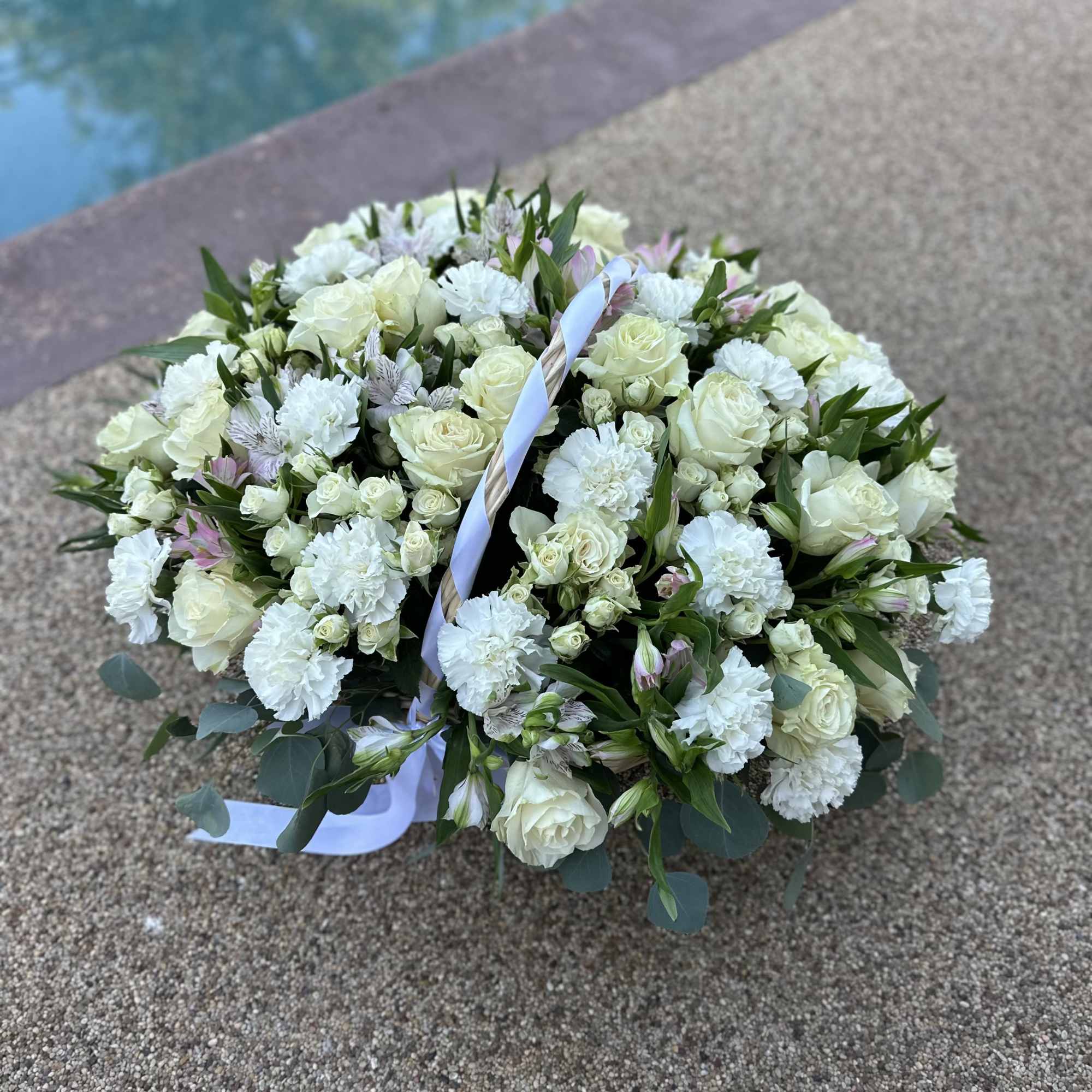 Round bouquet of white roses and carnations with a pale ribbon