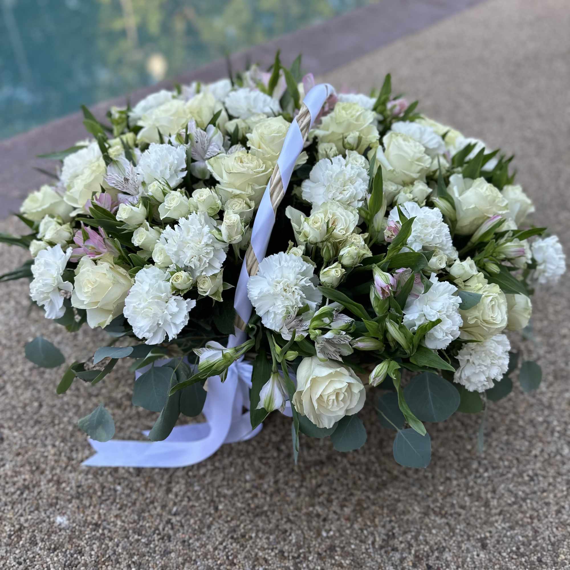 Large white floral basket arrangement with roses and carnations