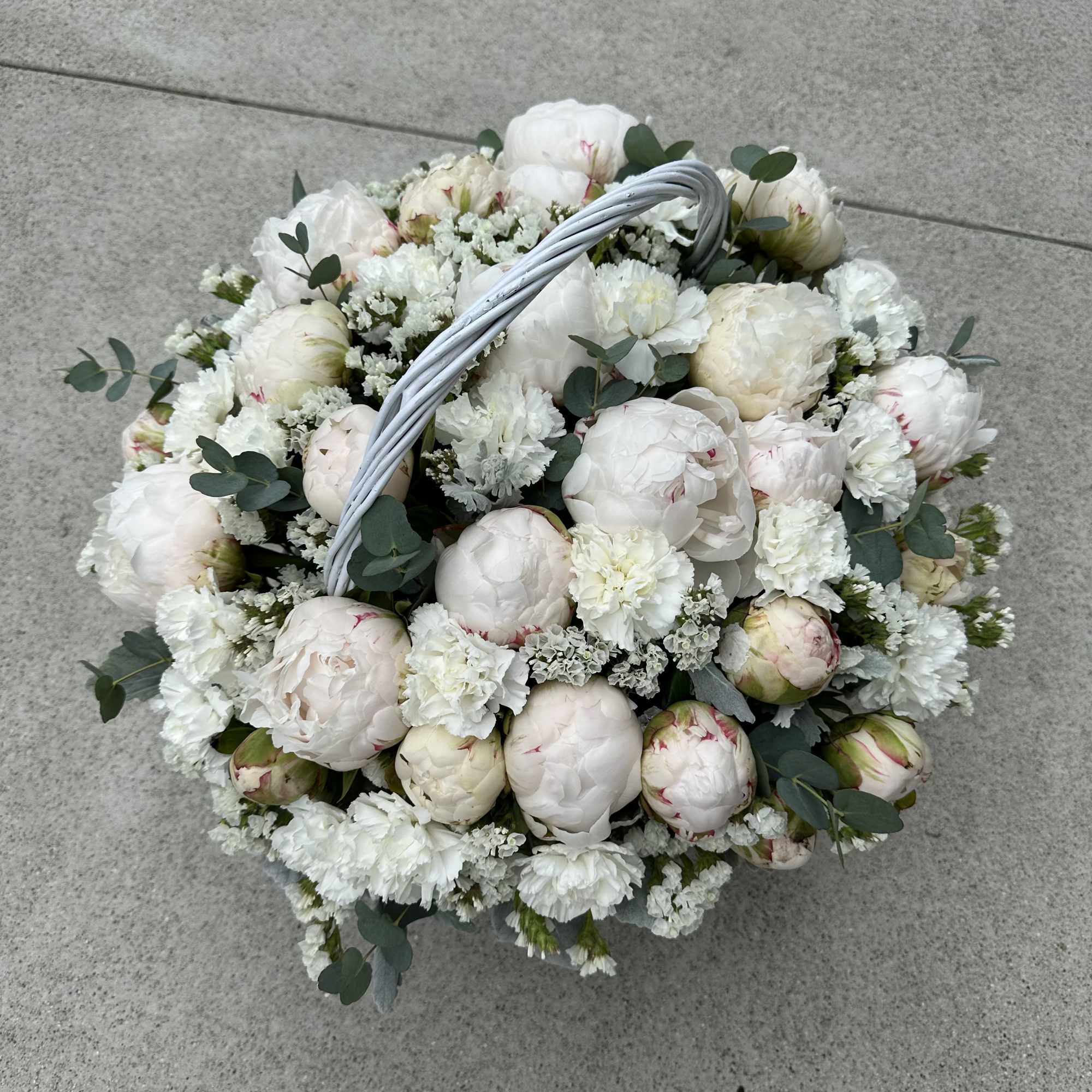 White peony bouquet with eucalyptus in a white basket