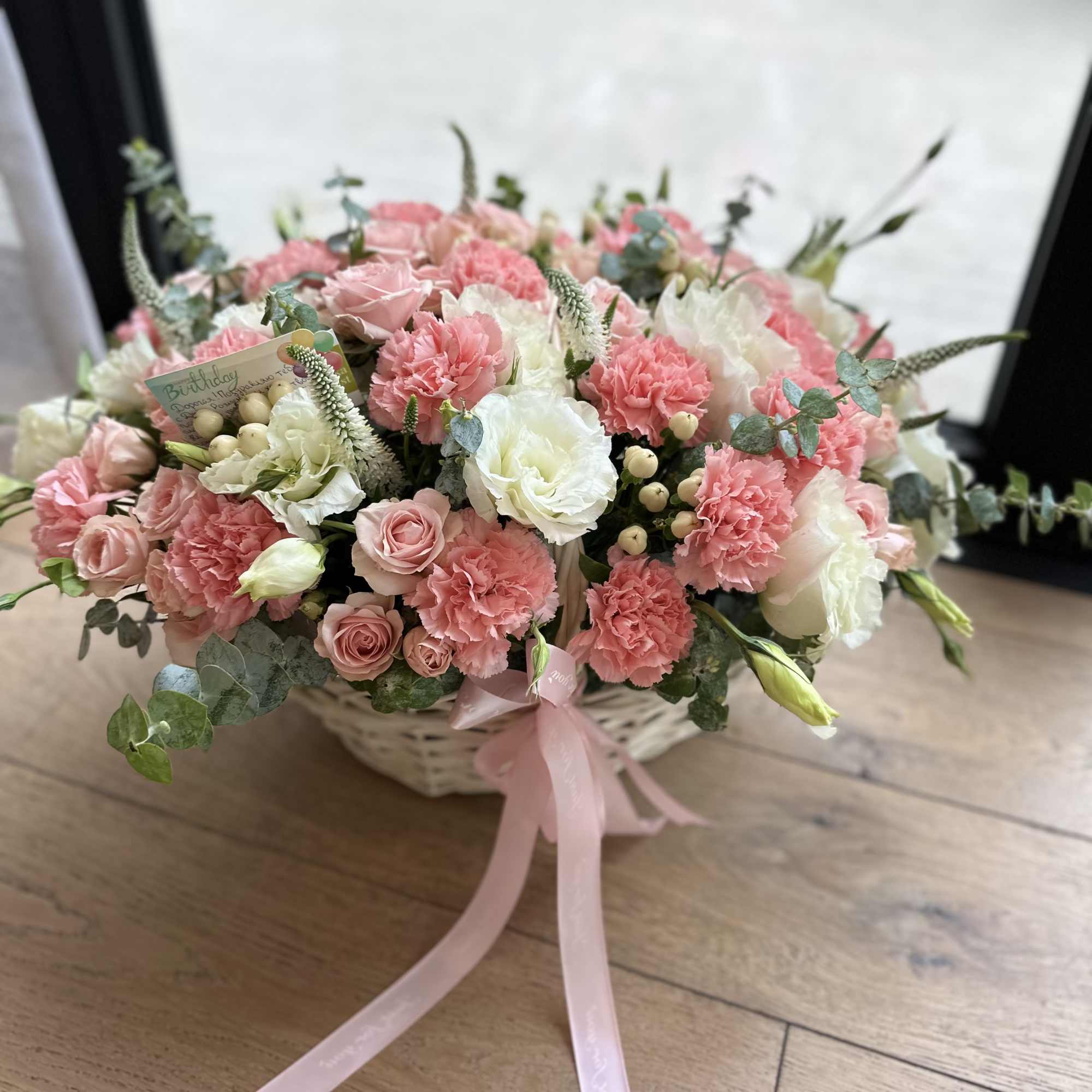 Pink and white flower basket with a ribbon bow