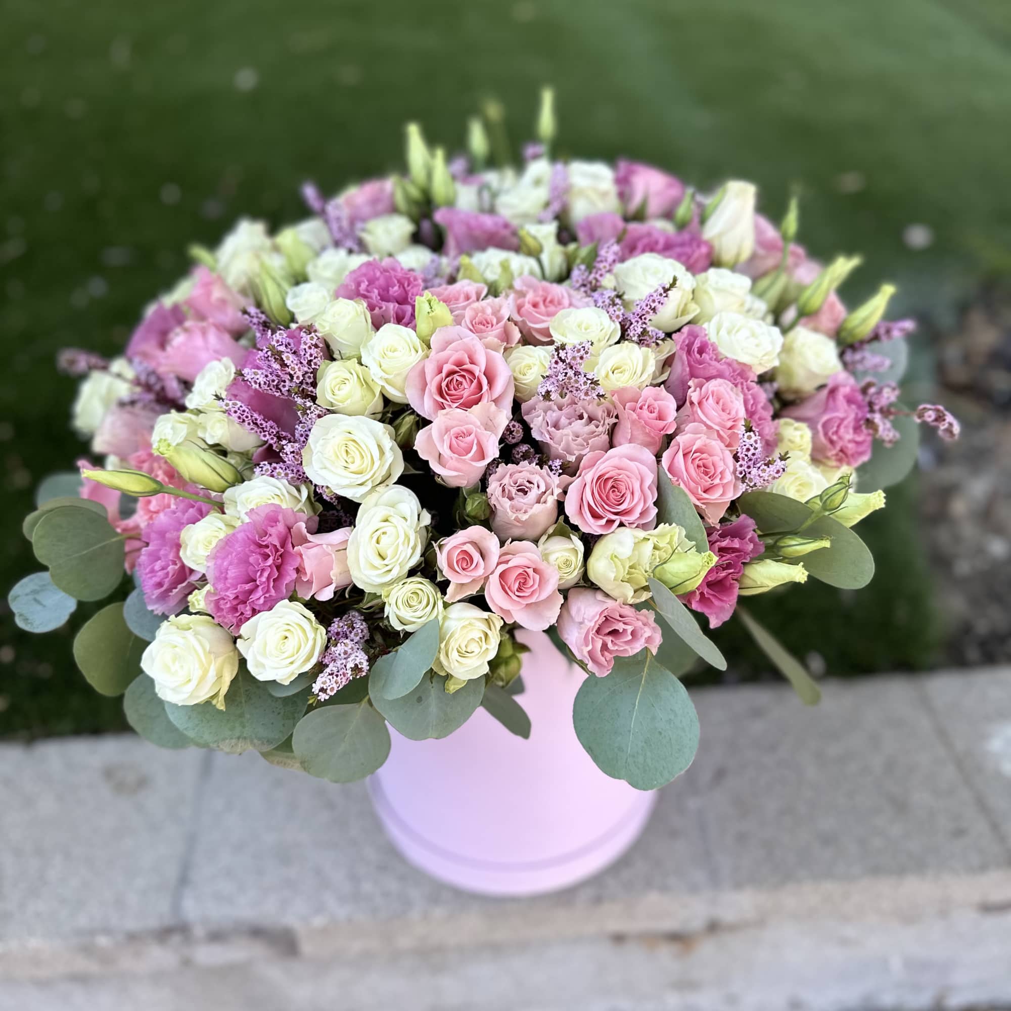 Pink and white rose bouquet in a pale pink vase
