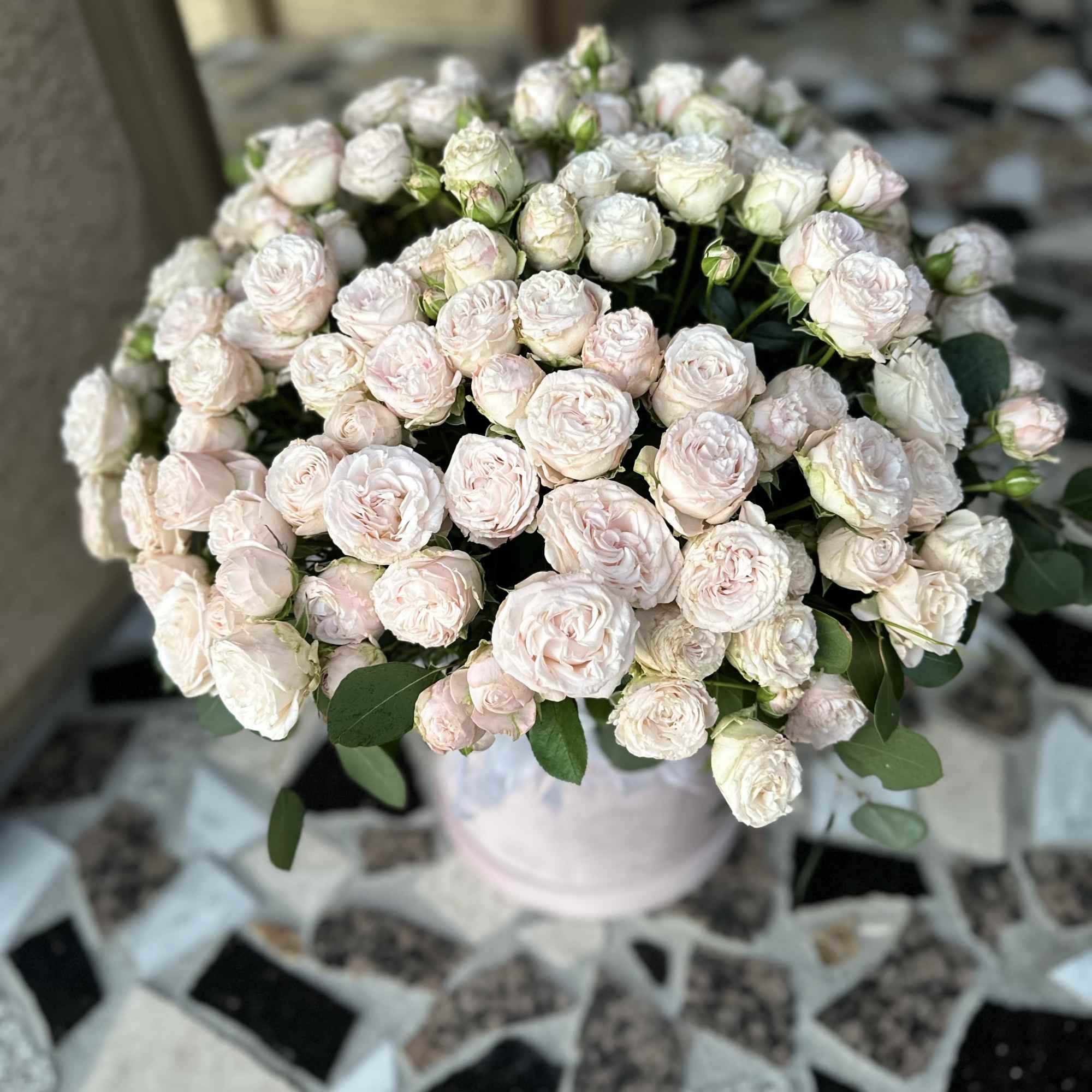 Bouquet of pale pink spray roses in a light vase