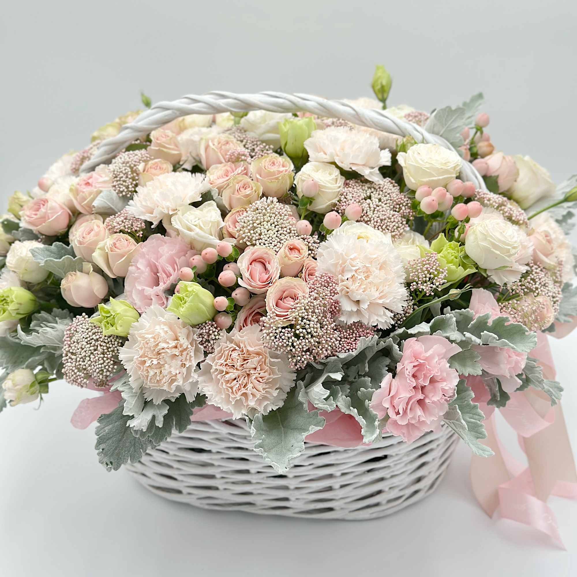 Pastel flower basket with pink and white blooms in a white wicker basket