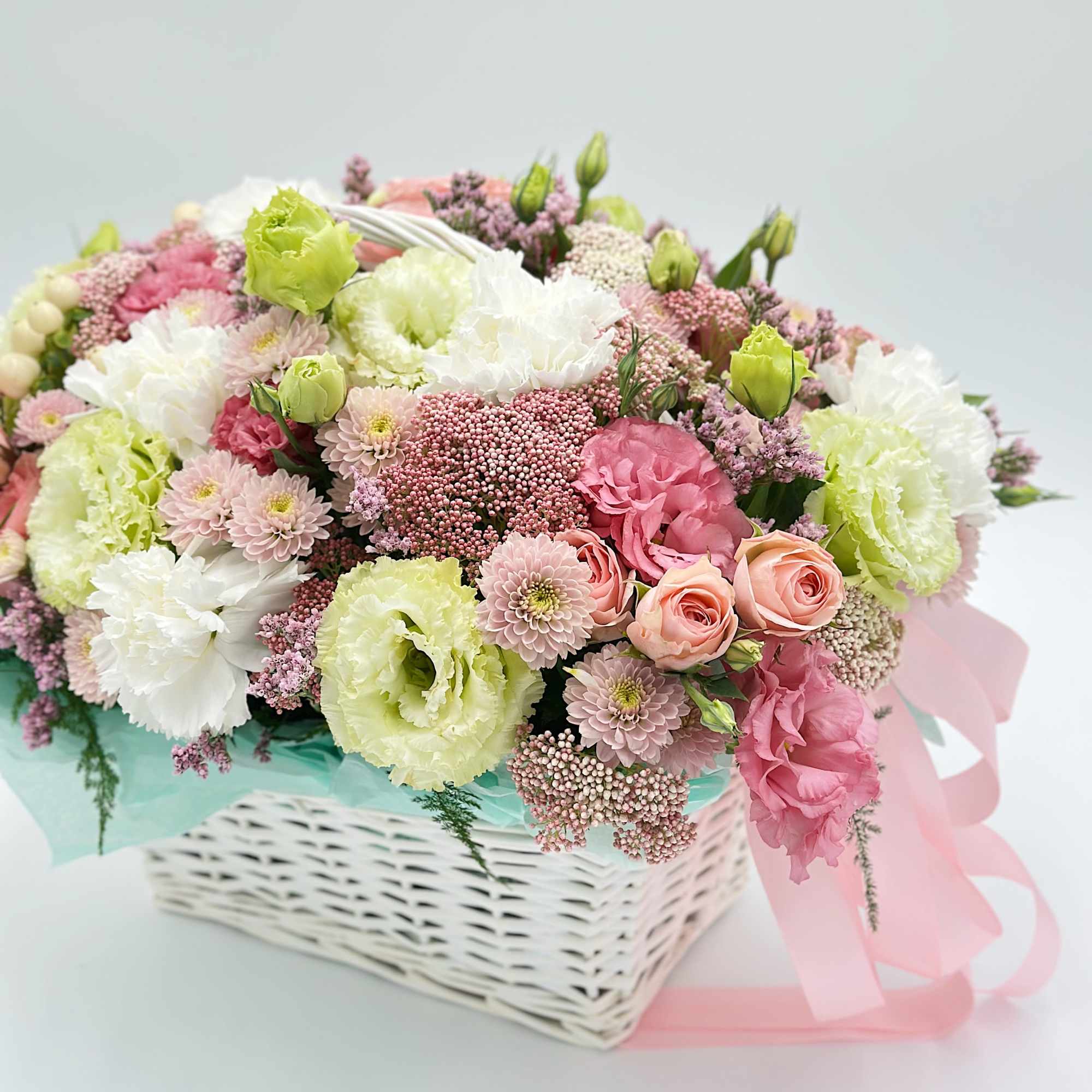 Pastel bouquet in a white basket with pink ribbon