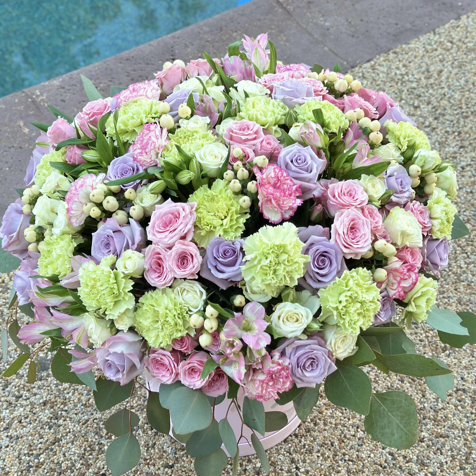 Large pastel bouquet of roses, carnations, and alstroemeria in a round box, photo 3 of 4