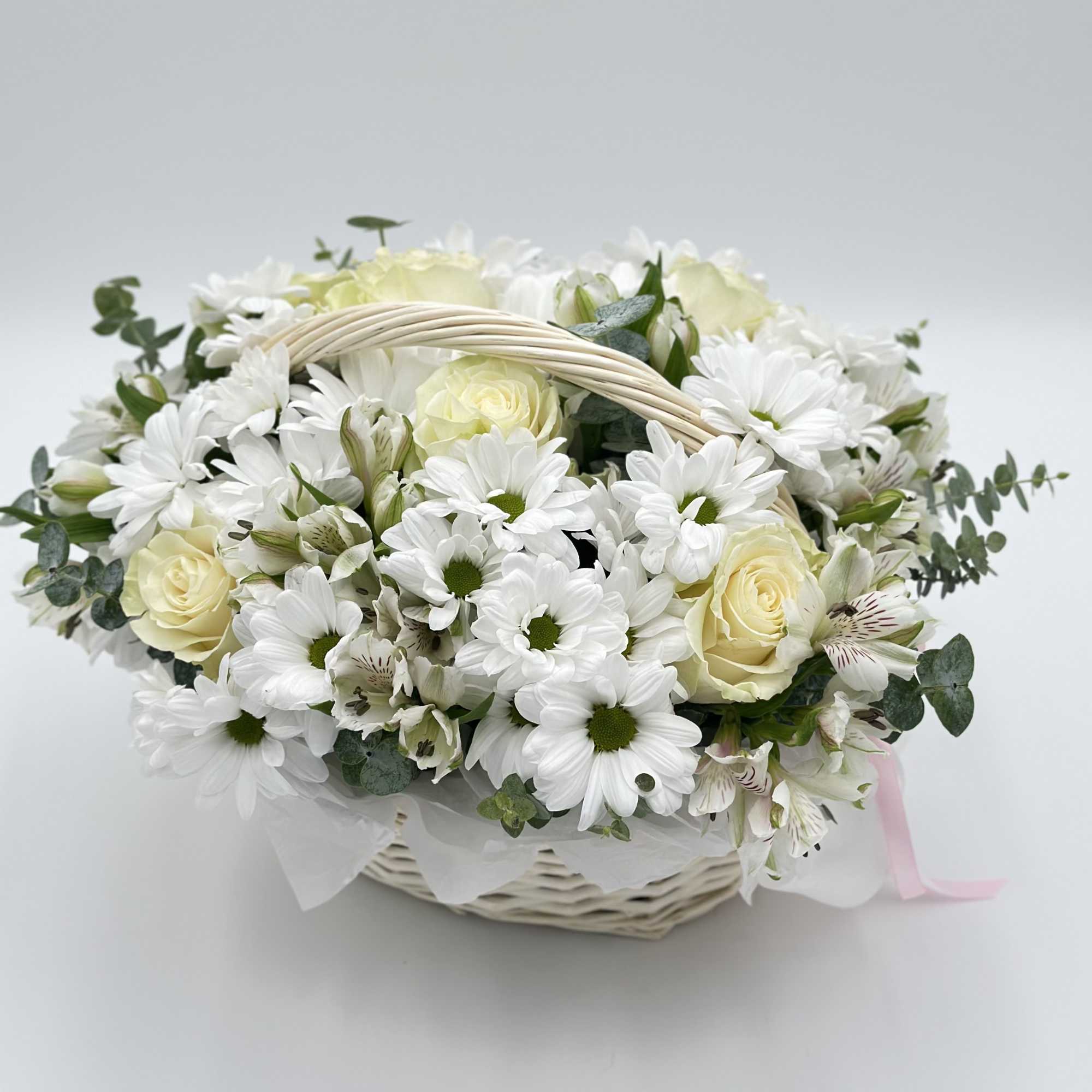 White daisies and cream roses in a wicker basket