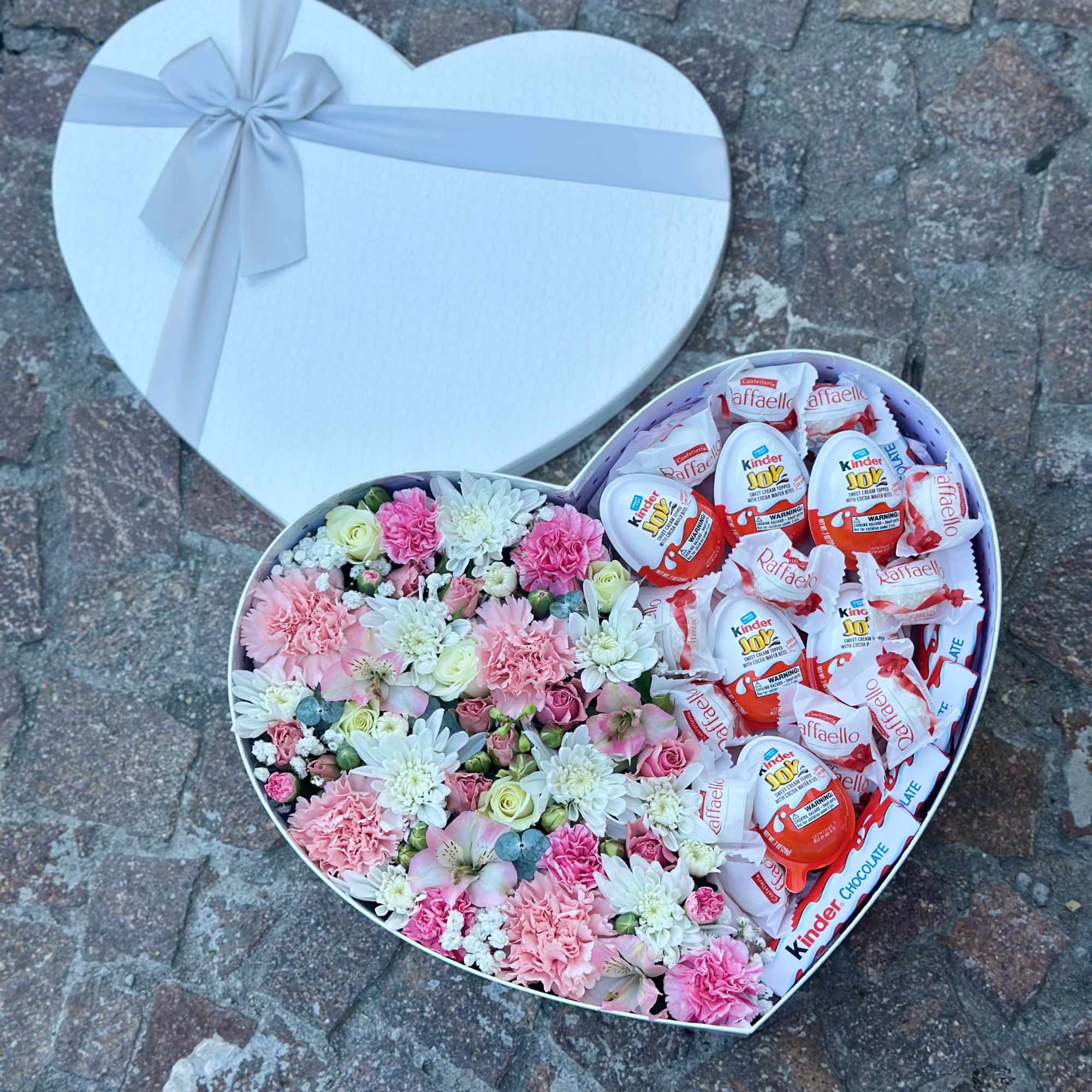 Heart-shaped gift box with pink flowers and chocolates