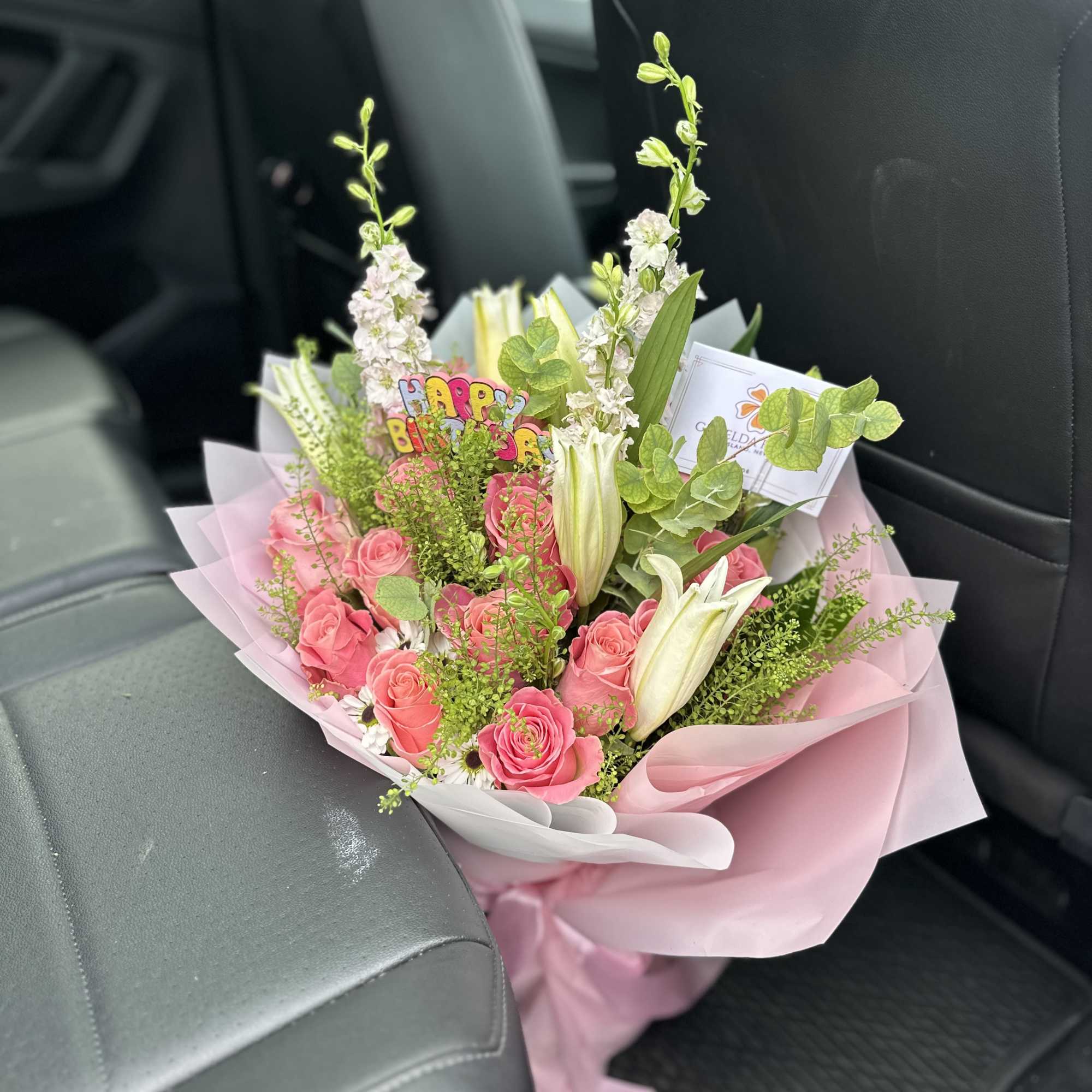 Pink rose bouquet with white lilies and a Happy Birthday topper