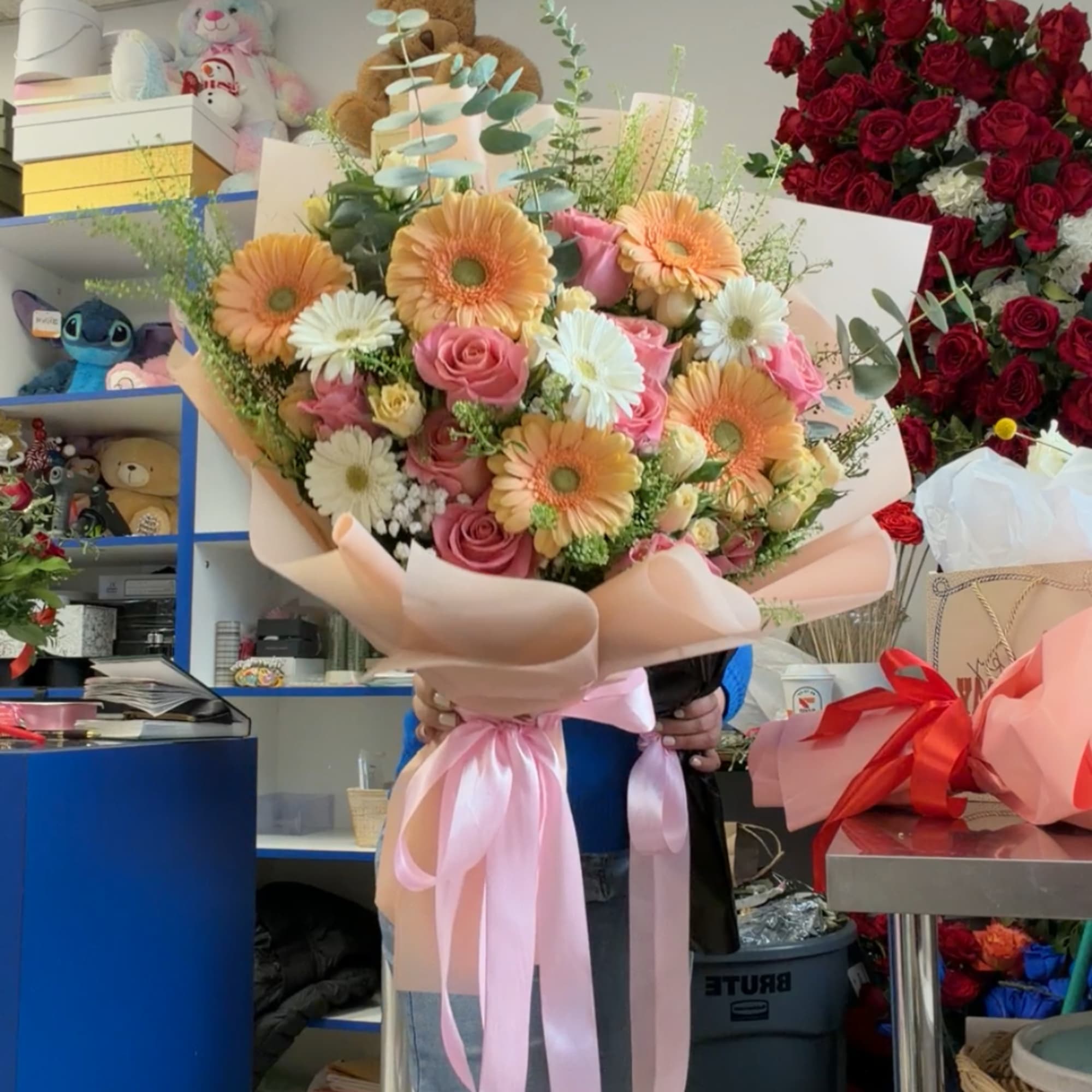 Large bouquet of pink roses and peach gerbera daisies wrapped in blush paper, photo 3 of 5