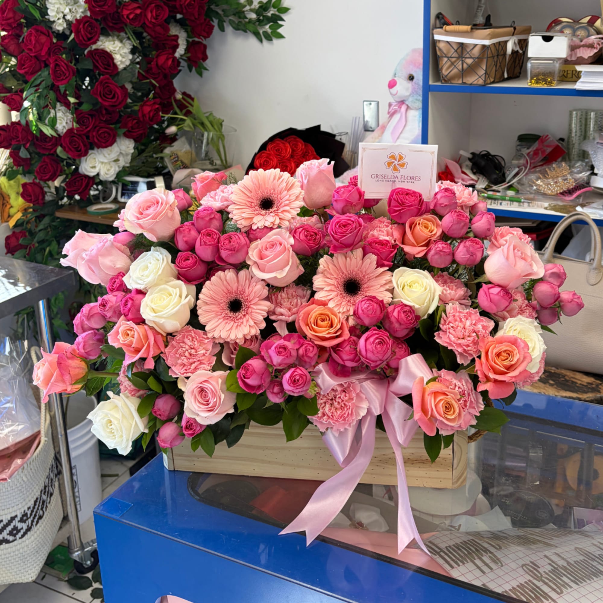 Large pink and red rose arrangement with gerbera daisies in a wooden box