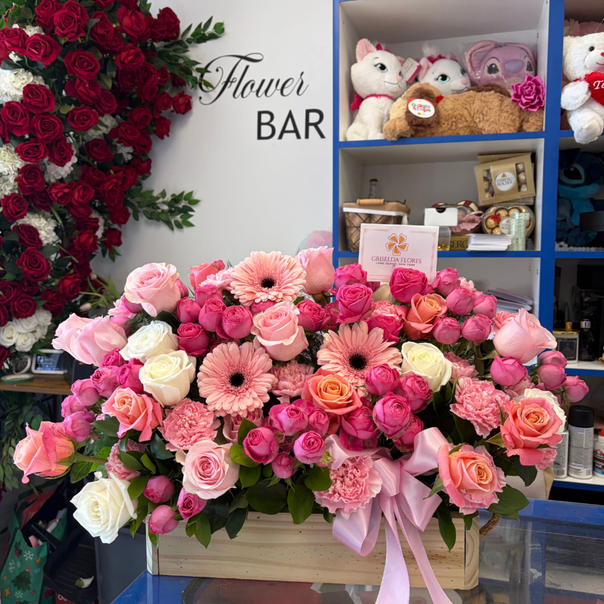 Pink and peach roses with gerbera daisies in a wooden box tied with a pink ribbon