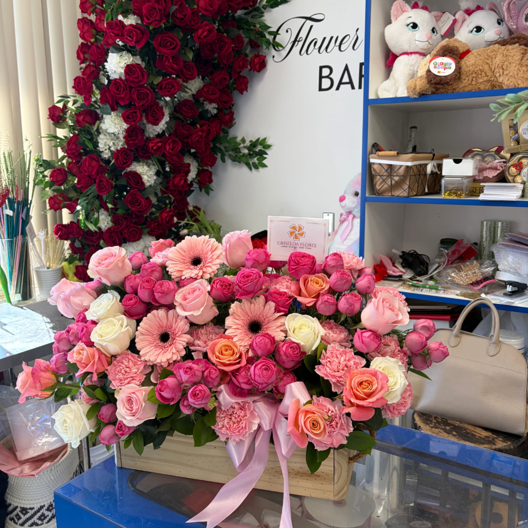 Pink and peach rose arrangement in a wooden box with a ribbon.