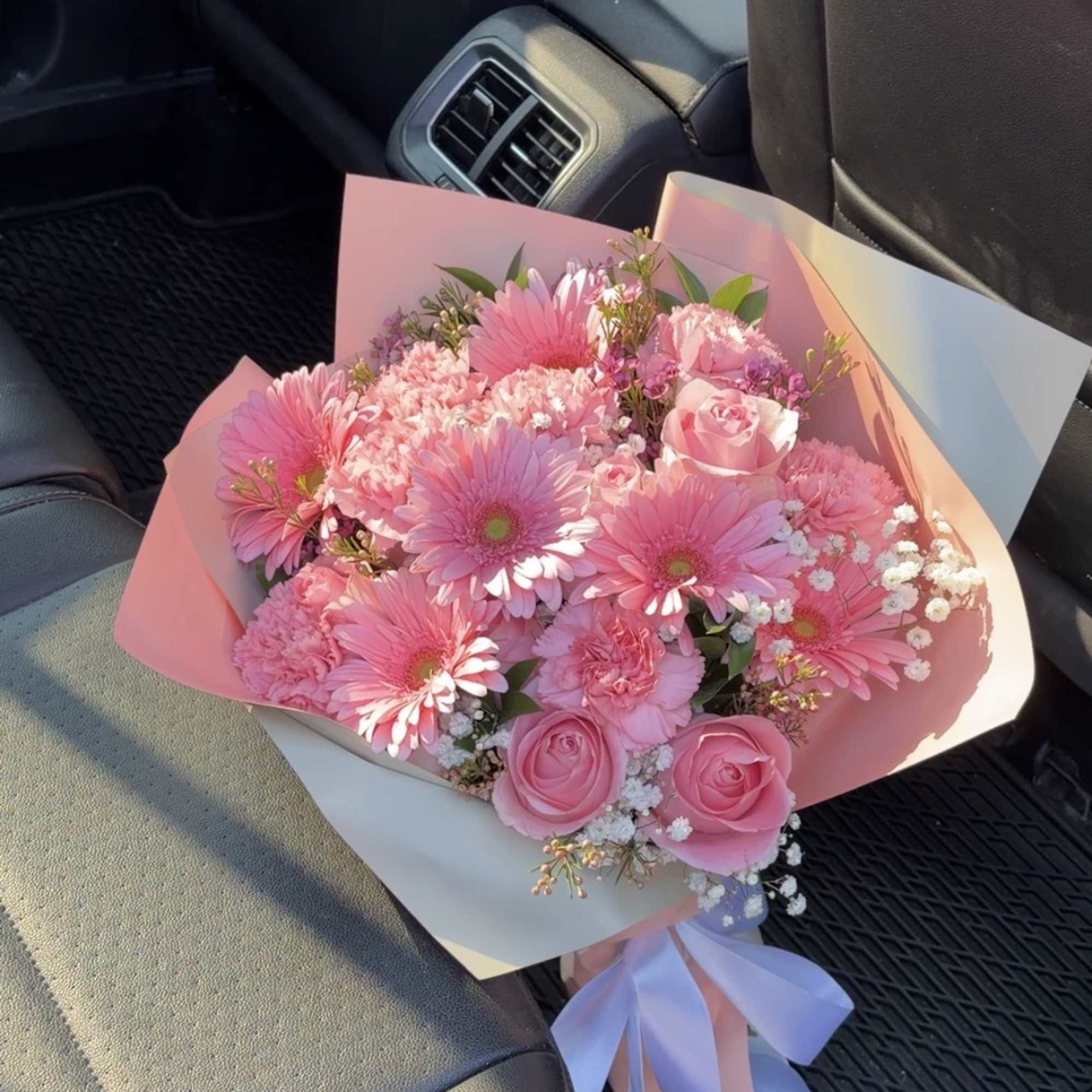 Pink bouquet with gerbera daisies and roses wrapped in pastel paper