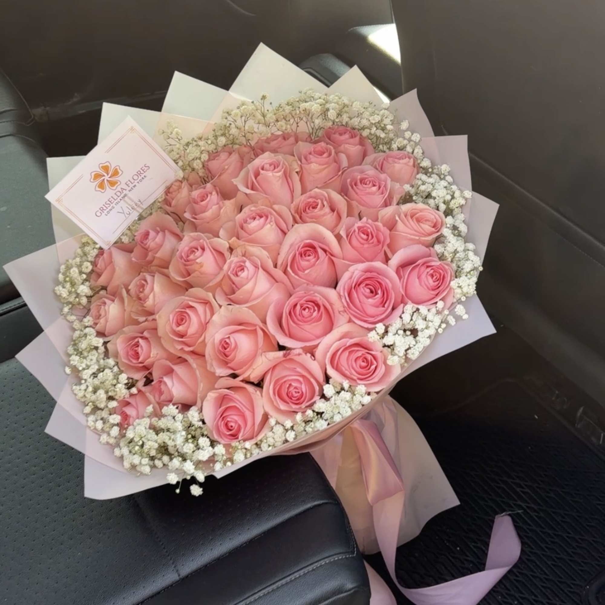 Bouquet of pink roses with white baby's breath and pink wrapping