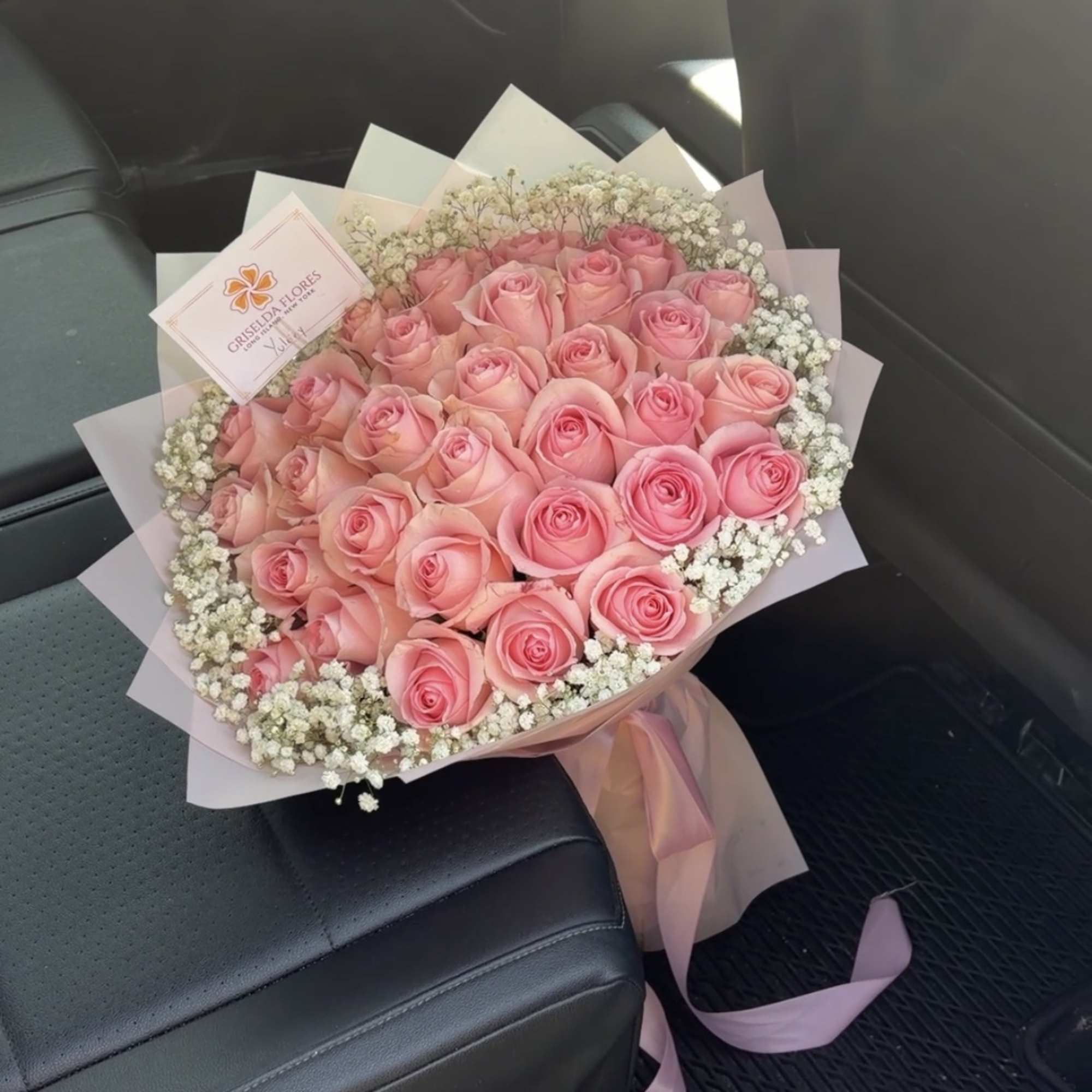 Bouquet of pink roses with white baby's breath in pink wrapping