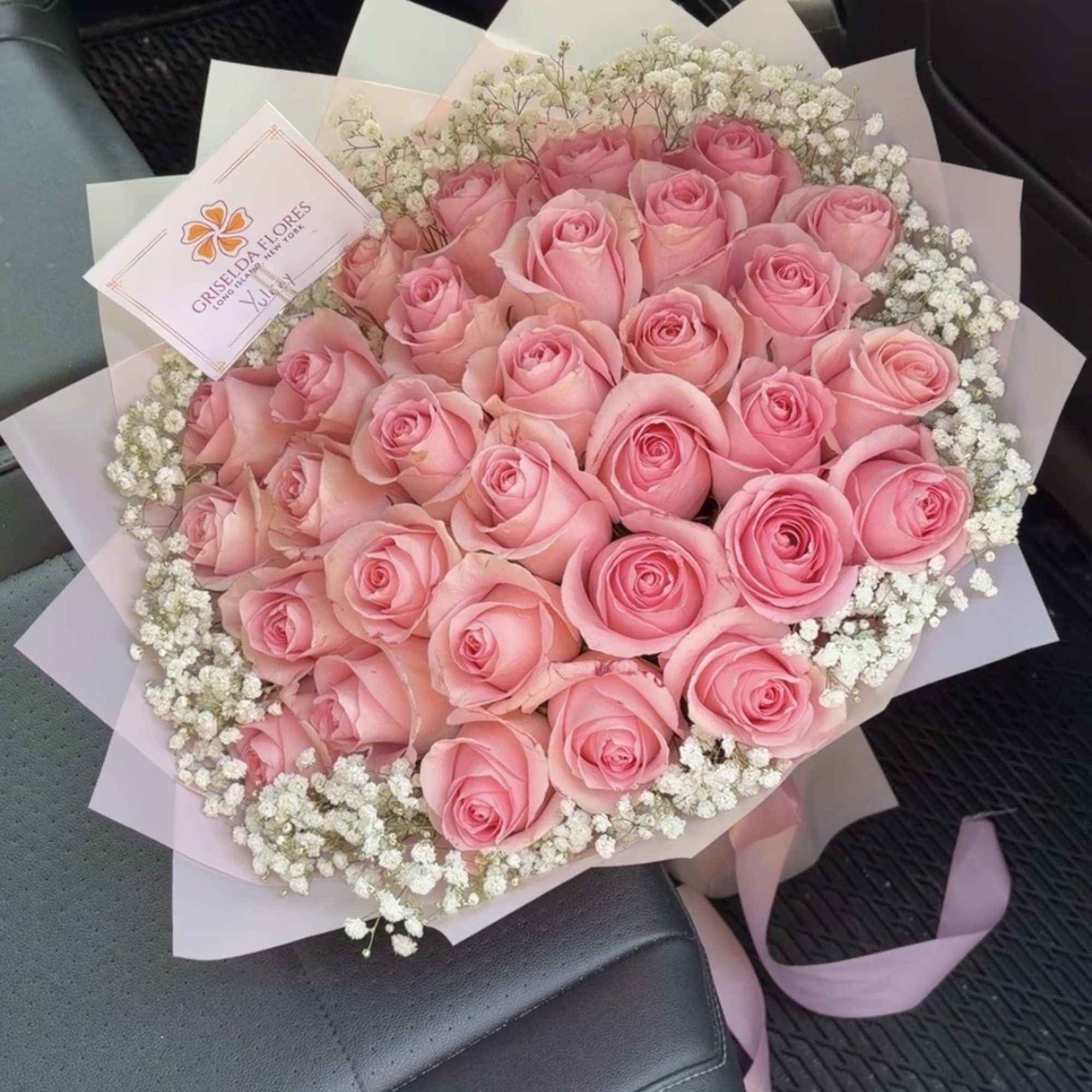 Bouquet of pink roses with white baby's breath in pastel wrap