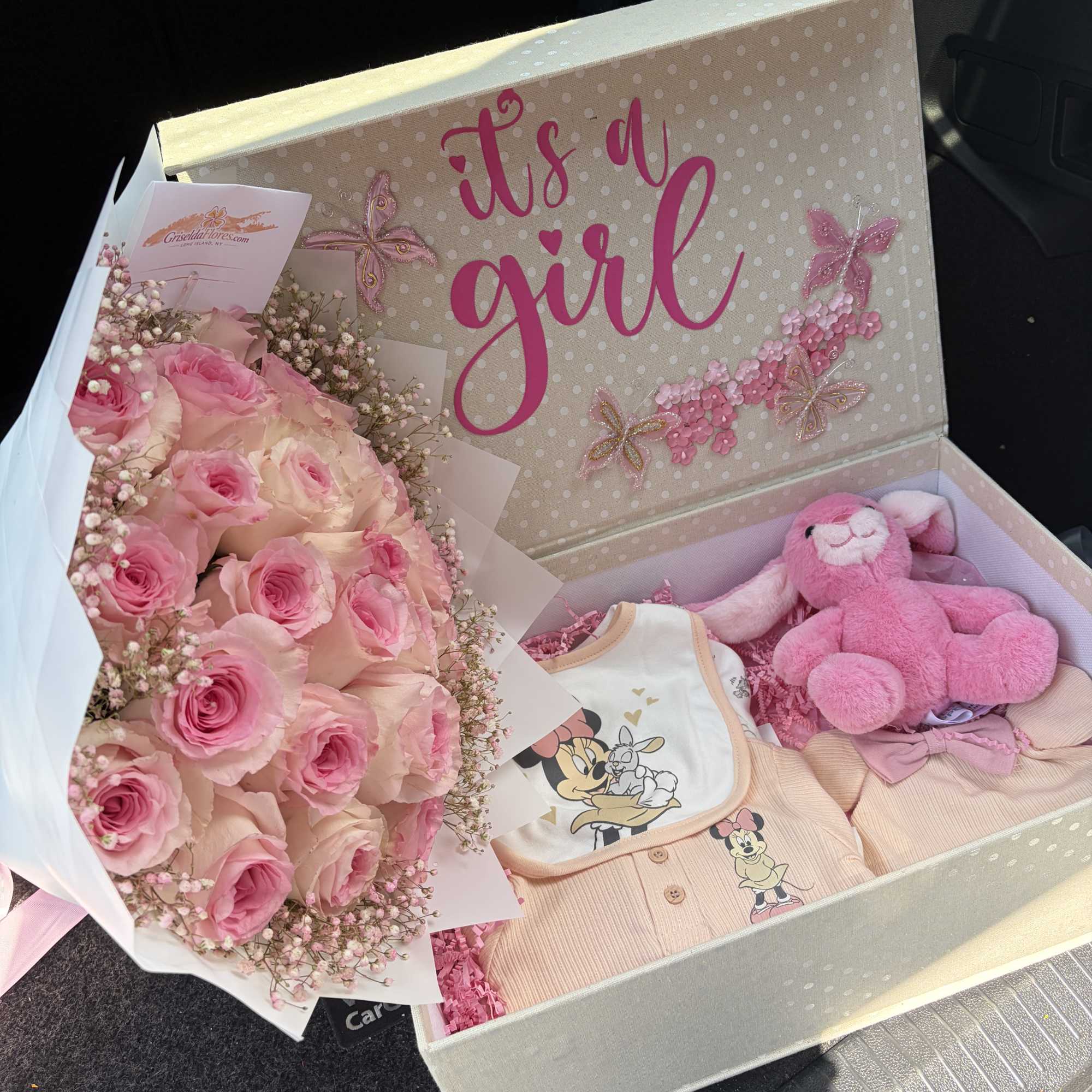 Pink rose bouquet with a plush bunny and baby clothes in a gift box