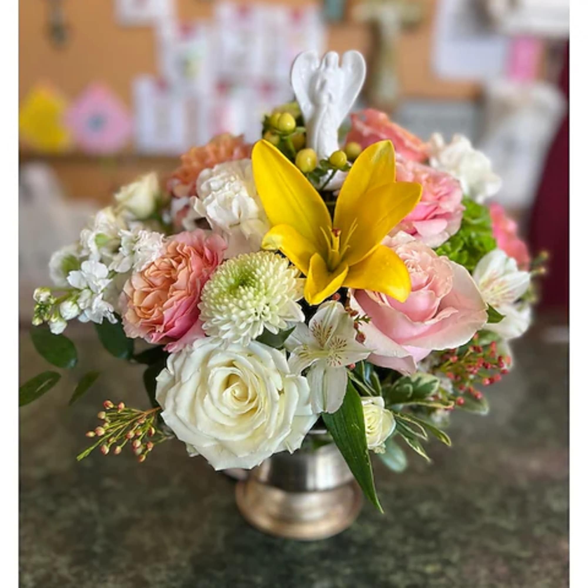 Mixed bouquet with a yellow lily and pink and white roses in a metal vase